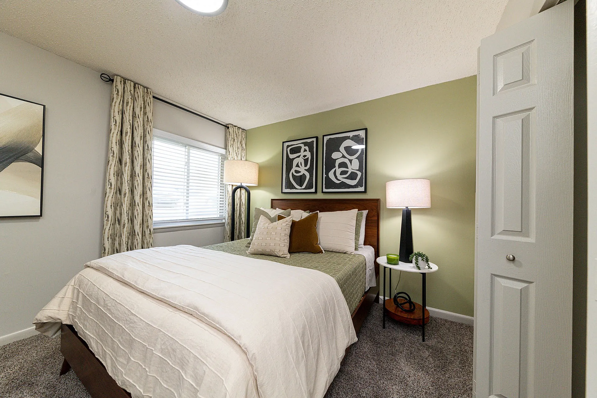 Cozy bedroom with soft lighting, elegant decor, and plush carpeting offering a serene retreat.
