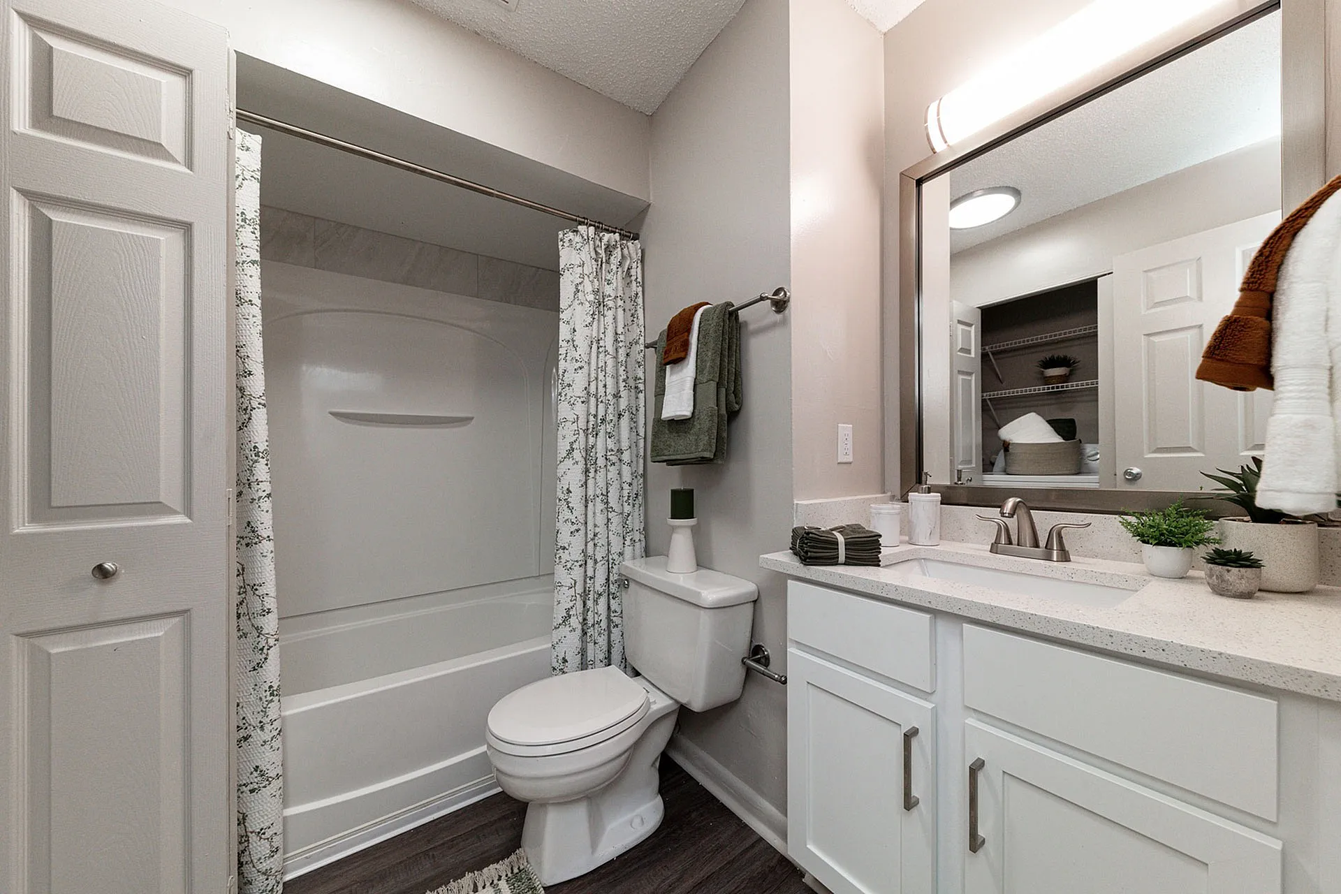 Contemporary bathroom featuring sleek white cabinetry, a spacious vanity, and a stylish floral shower curtain.