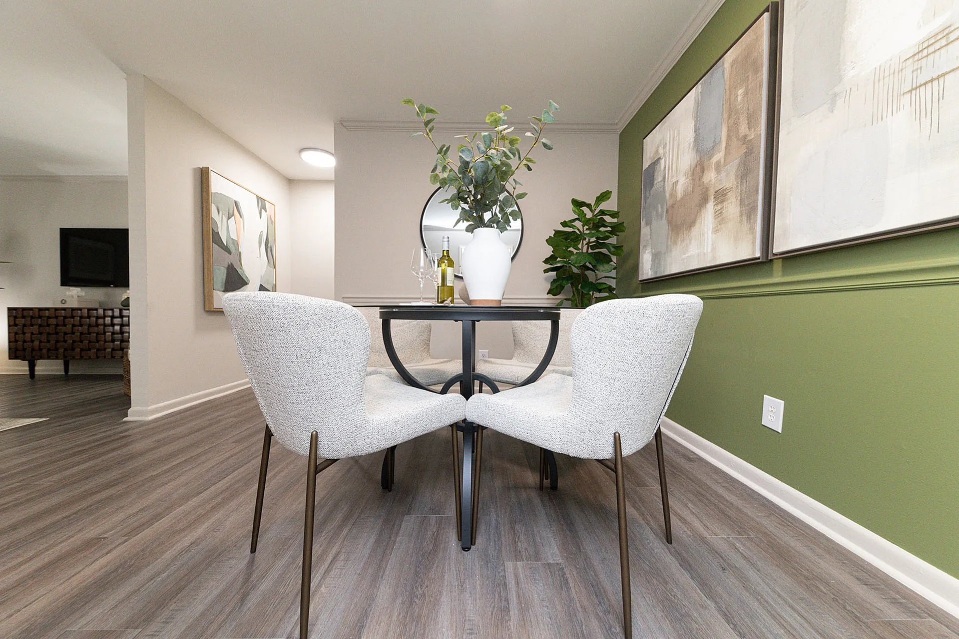 Chic dining area with elegant round table, plush chairs, and vibrant accents, capturing modern sophistication.