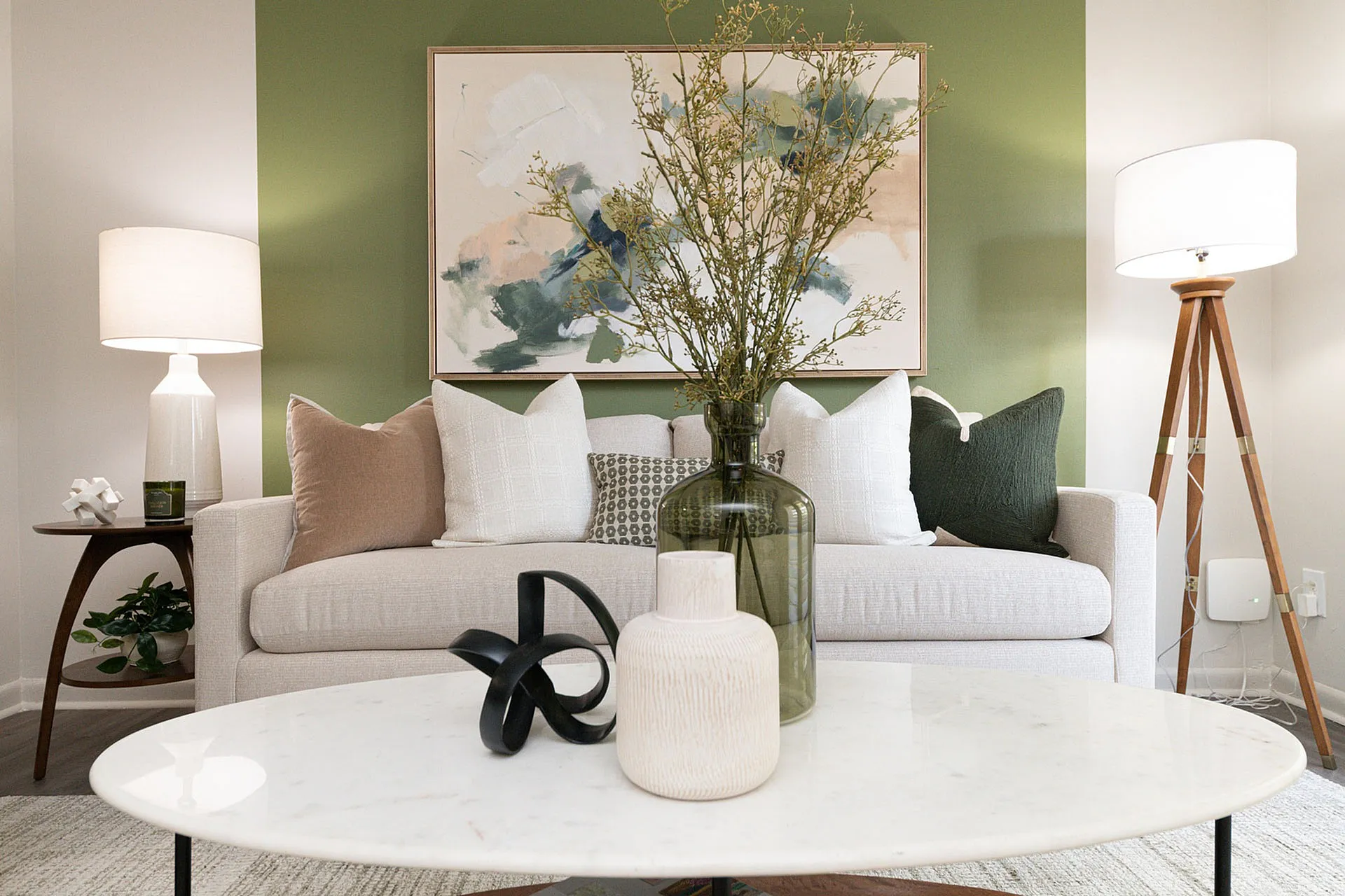 Chic and modern living room with stylish decor, featuring a comfy sofa adorned with elegant pillows, vibrant abstract art, and ambient lighting.