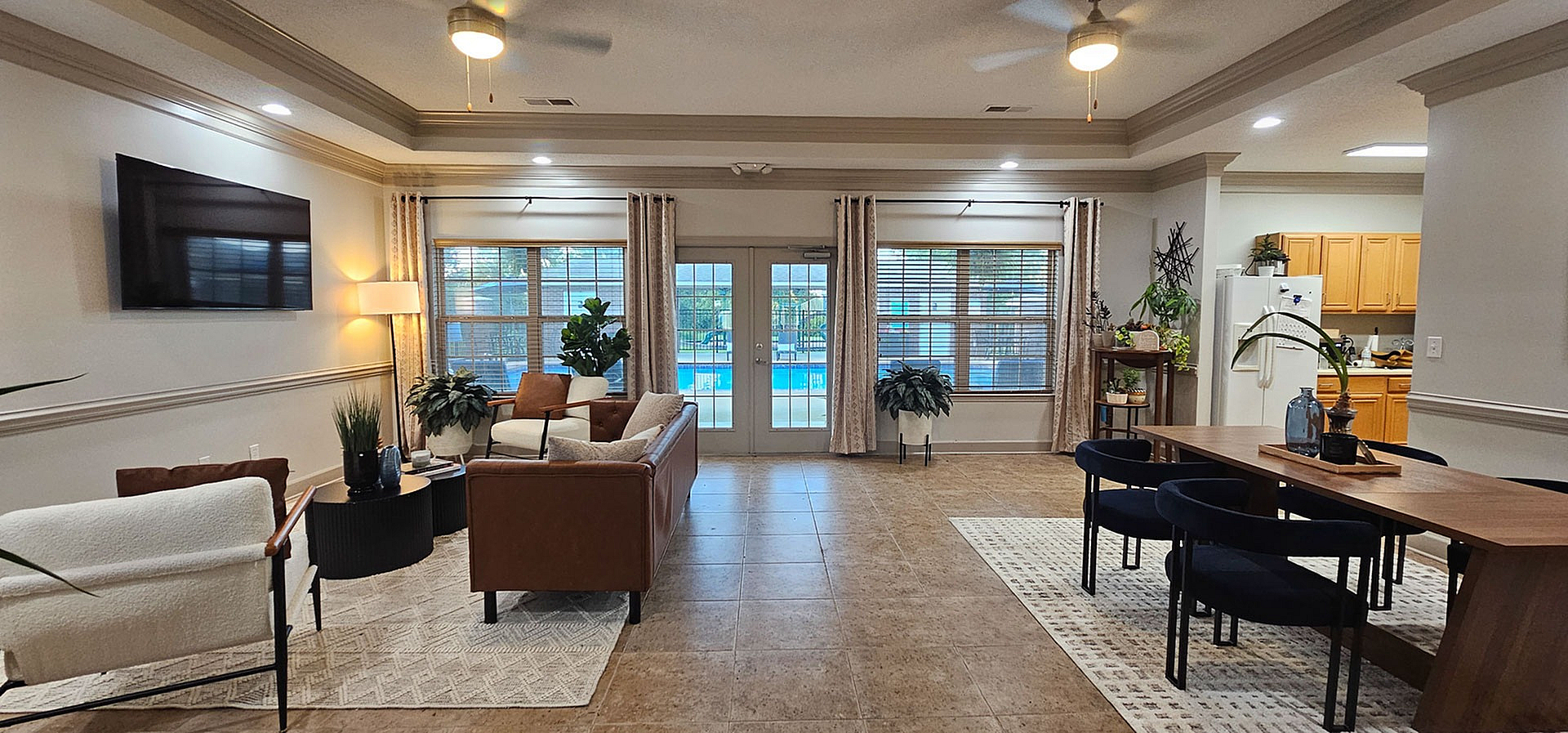 Bright and inviting open-concept living room with elegant furnishings, stylish lighting, and a view of the sparkling pool through large windows.