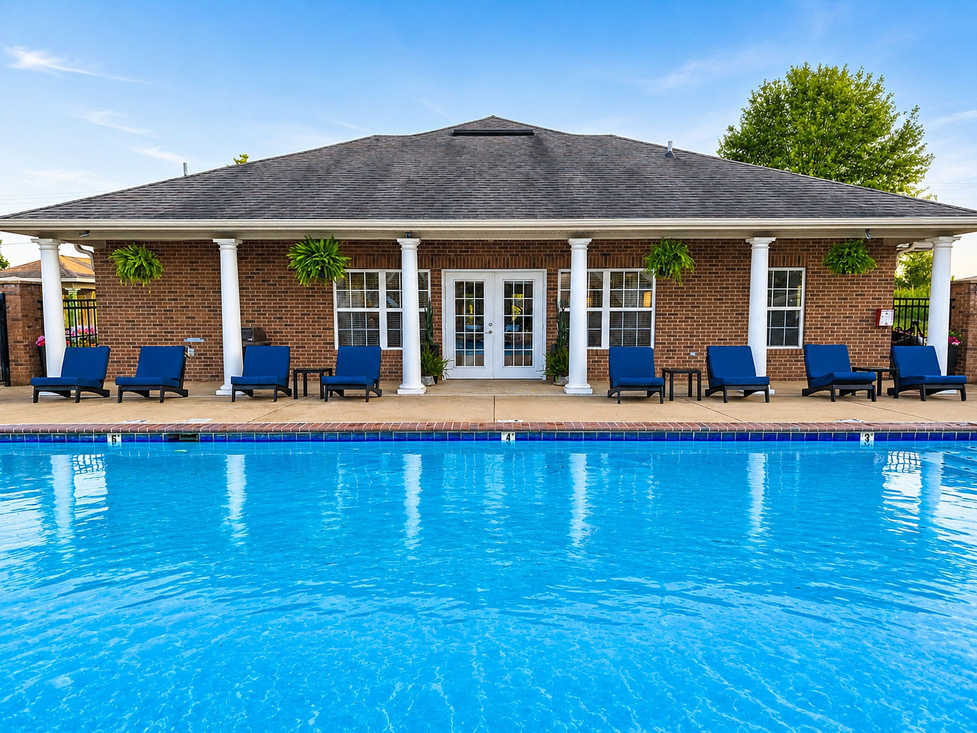 Inviting swimming pool area with sun loungers and lush greenery, perfect for relaxation and outdoor enjoyment.