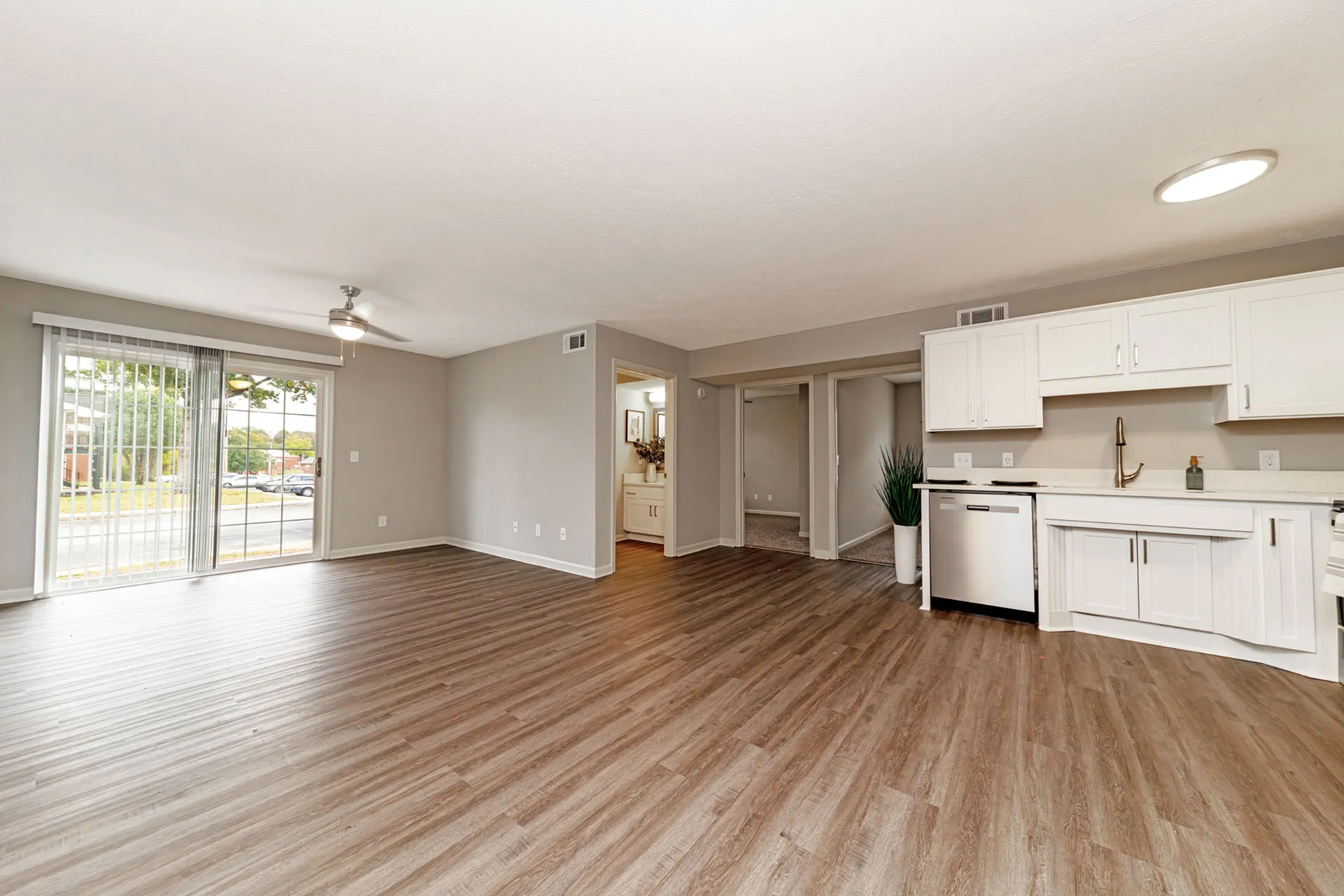 Bright, open-concept living space with modern kitchen, sleek flooring, and large windows offering natural light.