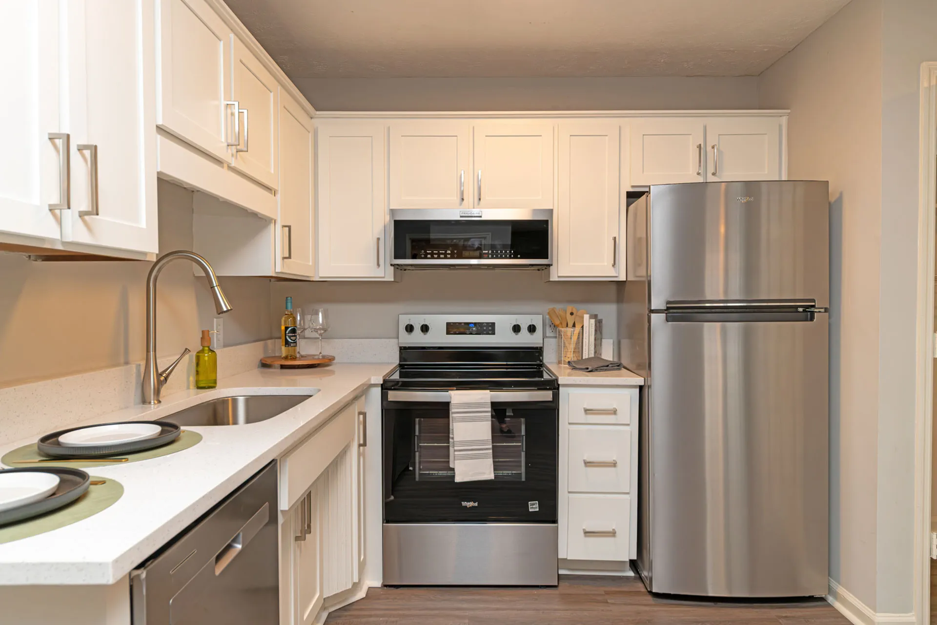 Modern kitchen with sleek white cabinets, stainless steel appliances, and elegant fixtures.