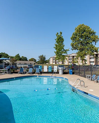 Inviting outdoor pool area with lounge chairs under a clear blue sky.