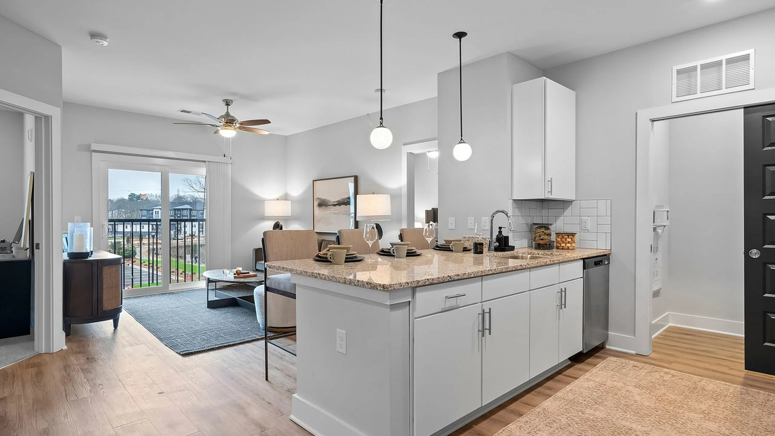 Bright and modern open-concept living area with stylish kitchen, featuring granite countertops and cozy seating, perfect for entertaining.