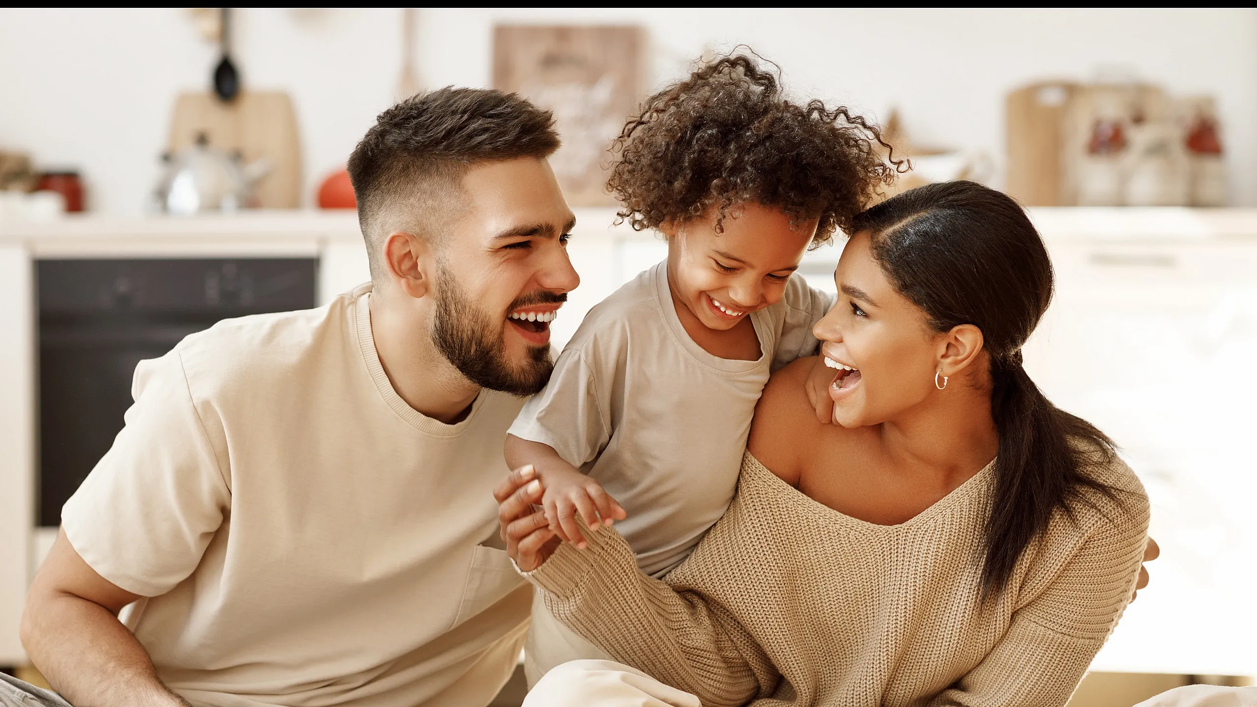 Joyful family enjoying quality time in a bright, modern kitchen space.