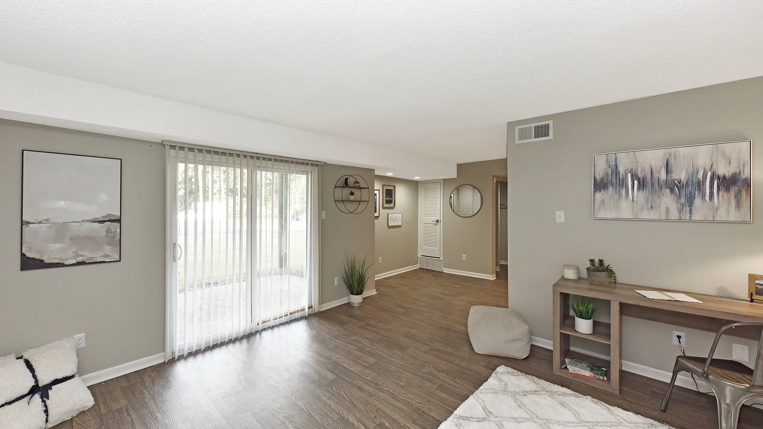 Bright and inviting living room with large sliding glass doors, chic decor, and elegant wood flooring, offering a perfect blend of comfort and style.