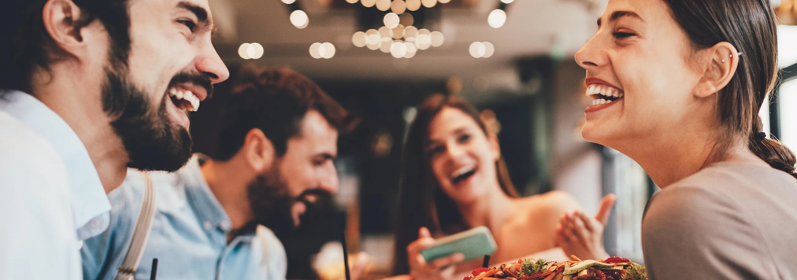 Vibrant group of friends enjoying a delightful meal at a trendy restaurant, filled with laughter and camaraderie.