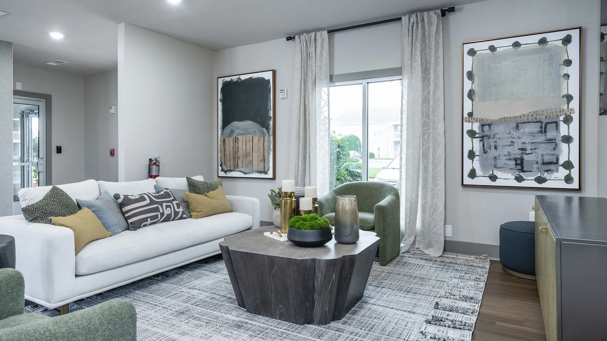 Elegant living room with modern art, cozy white sofa, and chic wooden coffee table, featuring abundant natural light.
