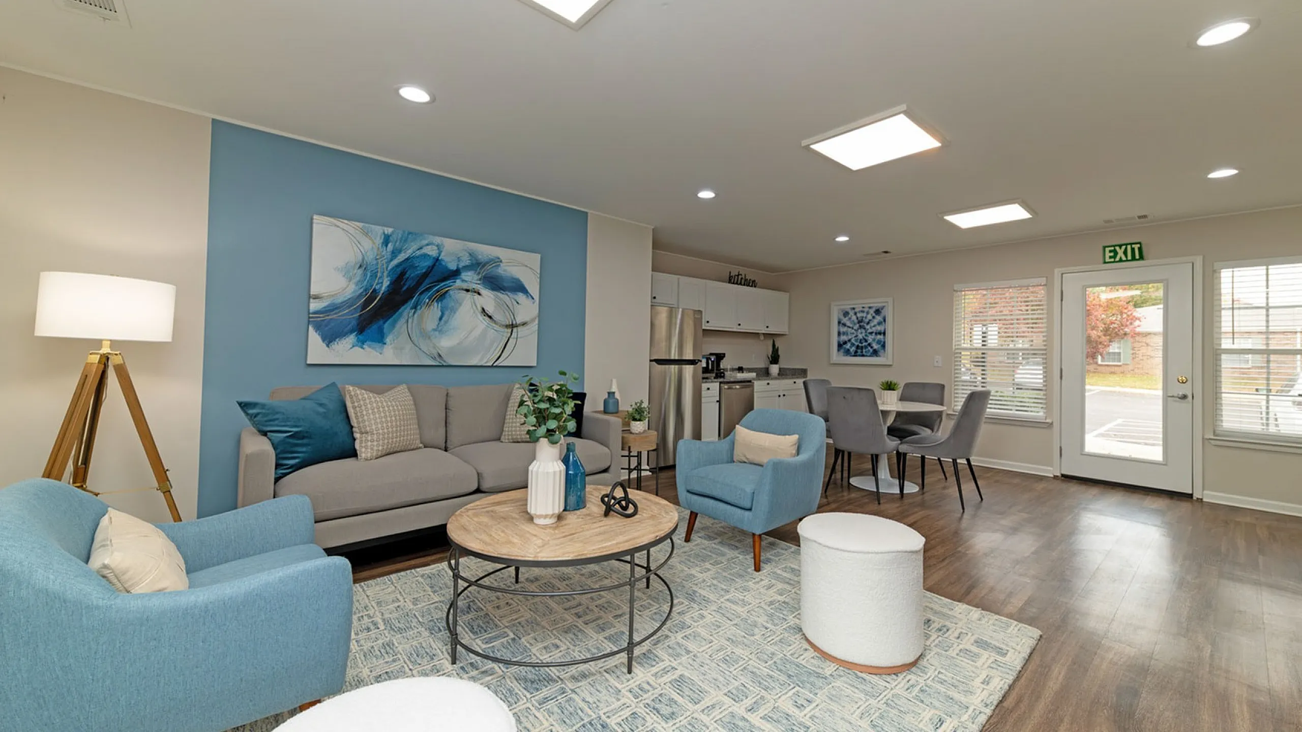 Elegant open-concept living space featuring modern decor, stylish blue accents, and abundant natural light.
