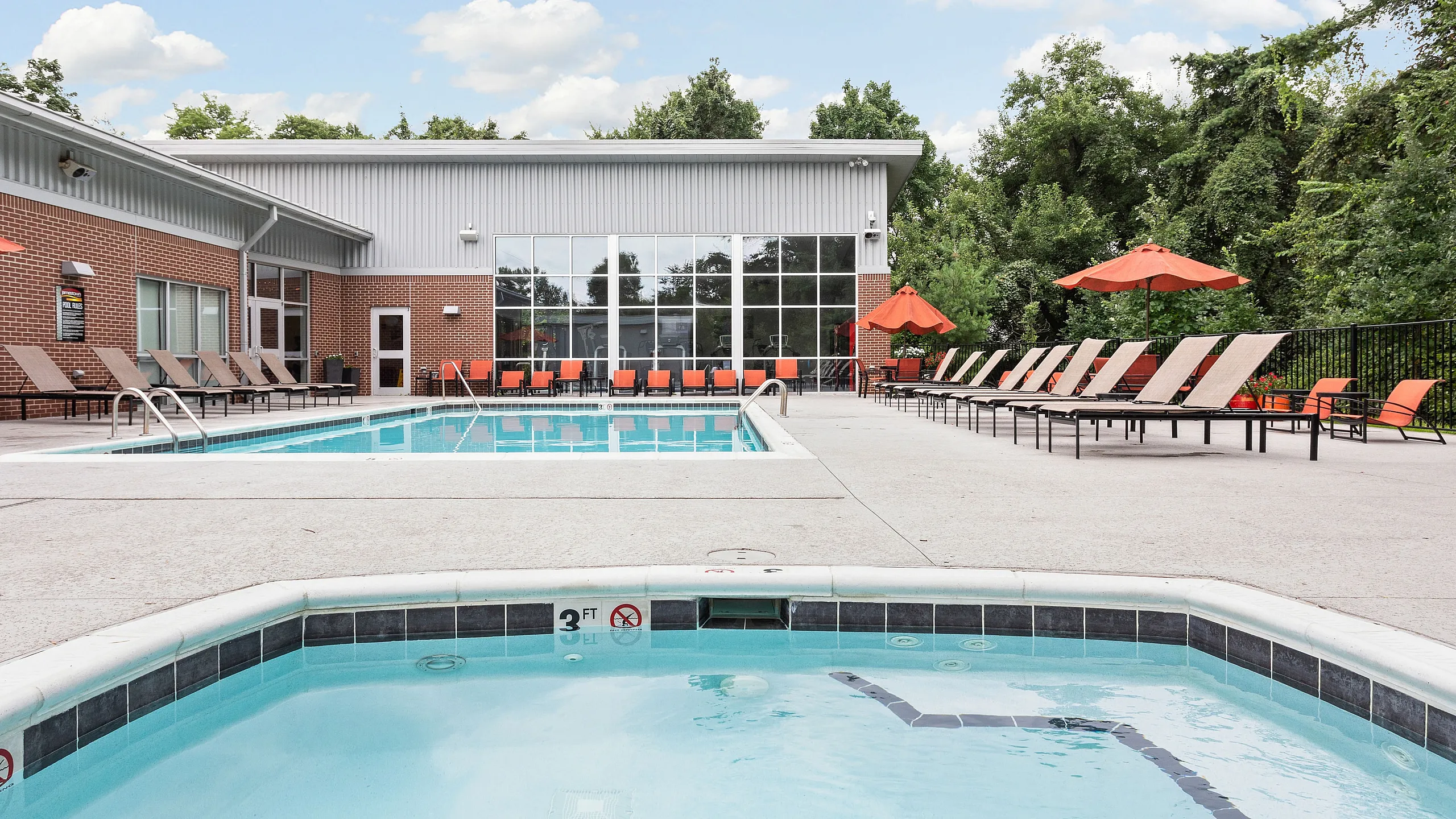 Inviting pool area with modern loungers and vibrant umbrellas, ideal for relaxation and leisure in a lush natural setting.