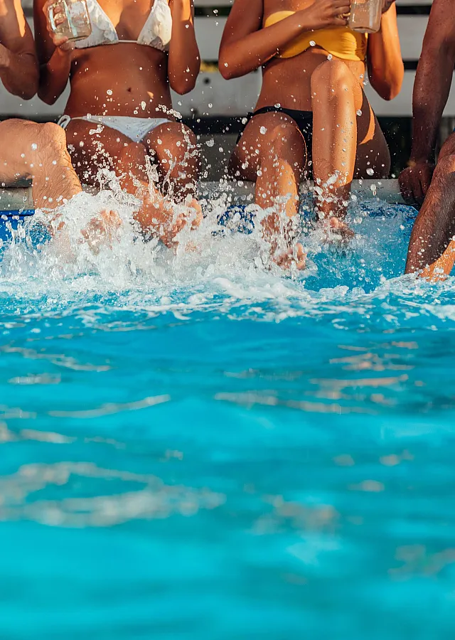 Vibrant poolside scene with friends enjoying a sunny day, feet splashing in crystal clear water.
