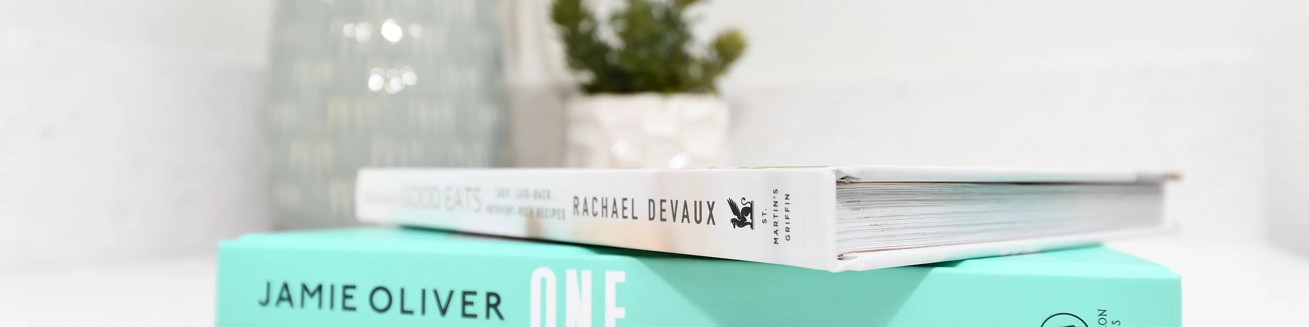 Elegant kitchen countertop decor with stylish cookbooks and a modern vase, creating a cozy ambience.