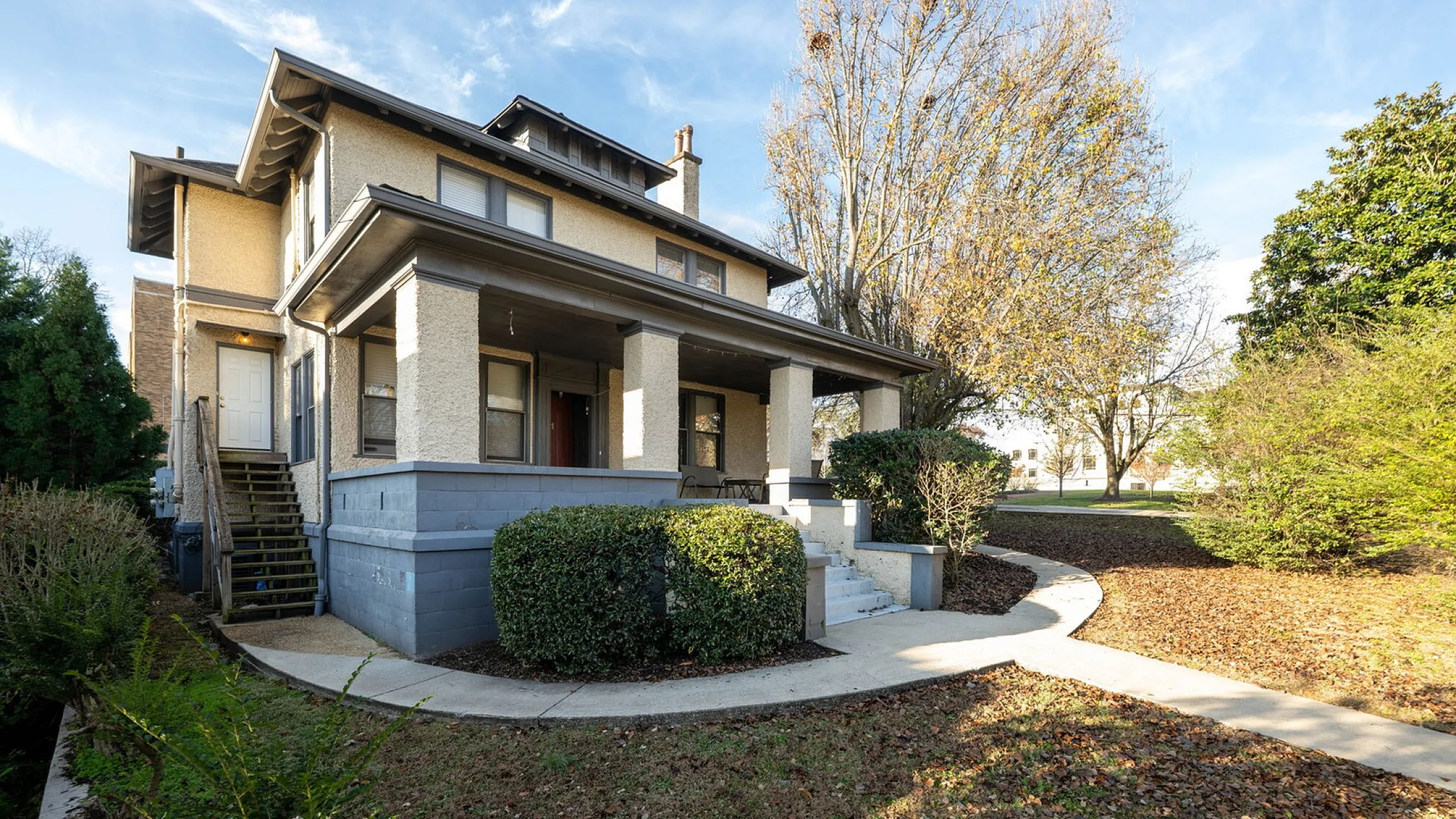 Charming two-story home with classic architecture, spacious front porch, and lush garden for a serene living experience.