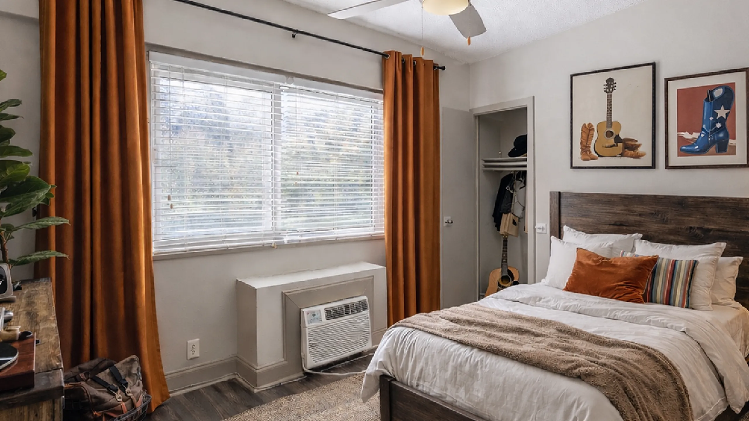 Cozy bedroom with plush bedding, warm wooden furniture, and earthy orange curtains, creating a serene and inviting atmosphere.
