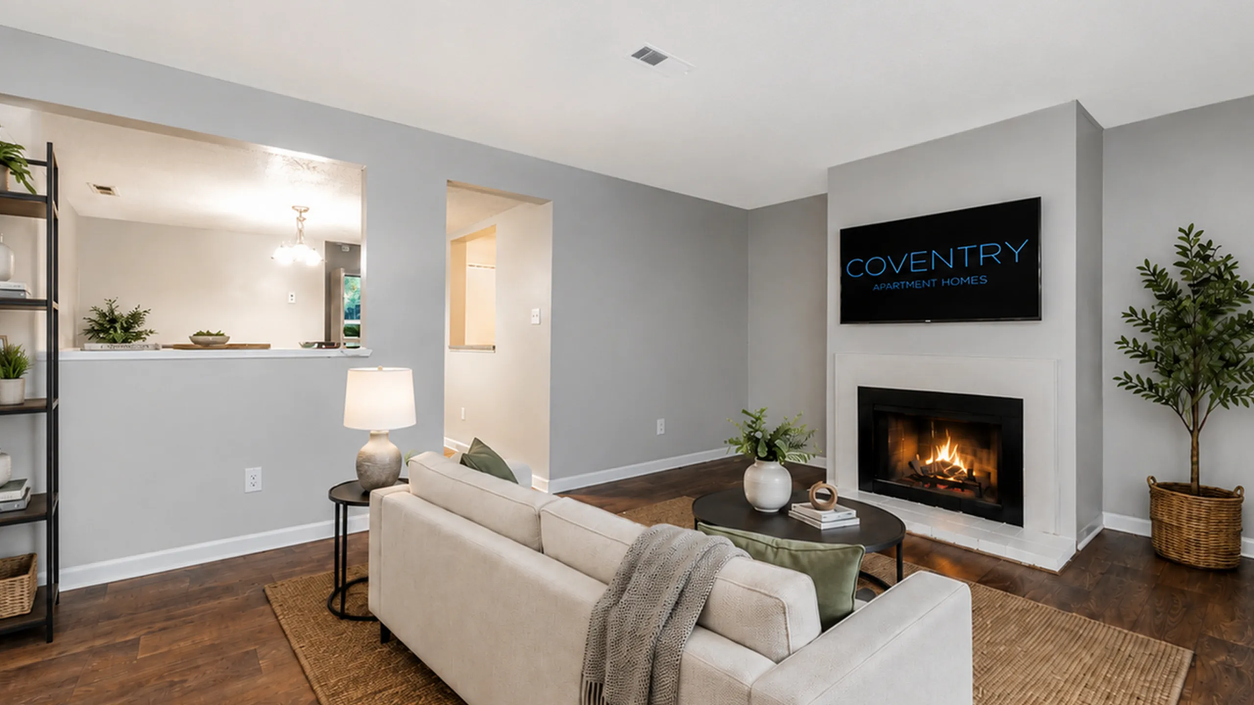 Inviting living room with a cozy fireplace, modern decor, and wooden flooring at Coventry Apartment Homes.
