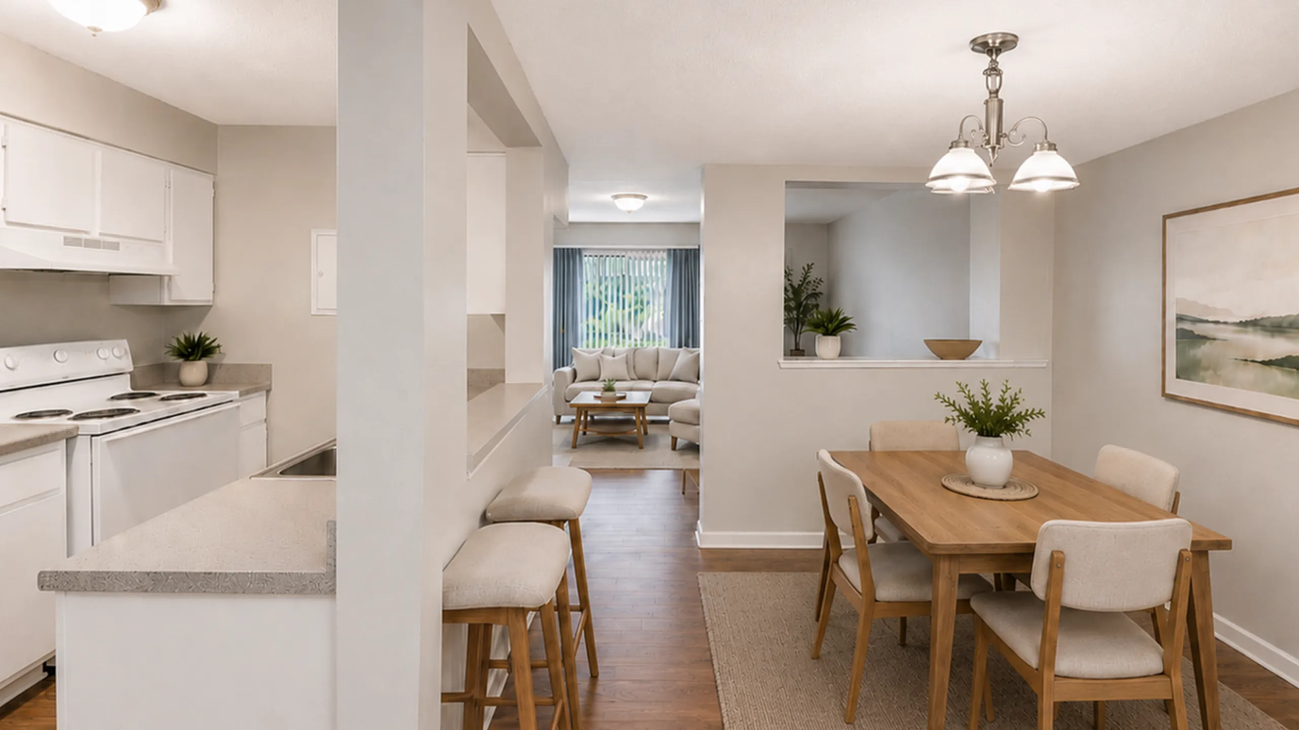 Modern open-plan living space featuring a stylish kitchen with bar seating, adjacent dining area with elegant wooden table, and a cozy living room with natural lighting.