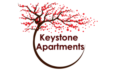 Elegant logo of Keystone Apartments featuring a stylized tree with vibrant red leaves, creating a welcoming and modern impression.