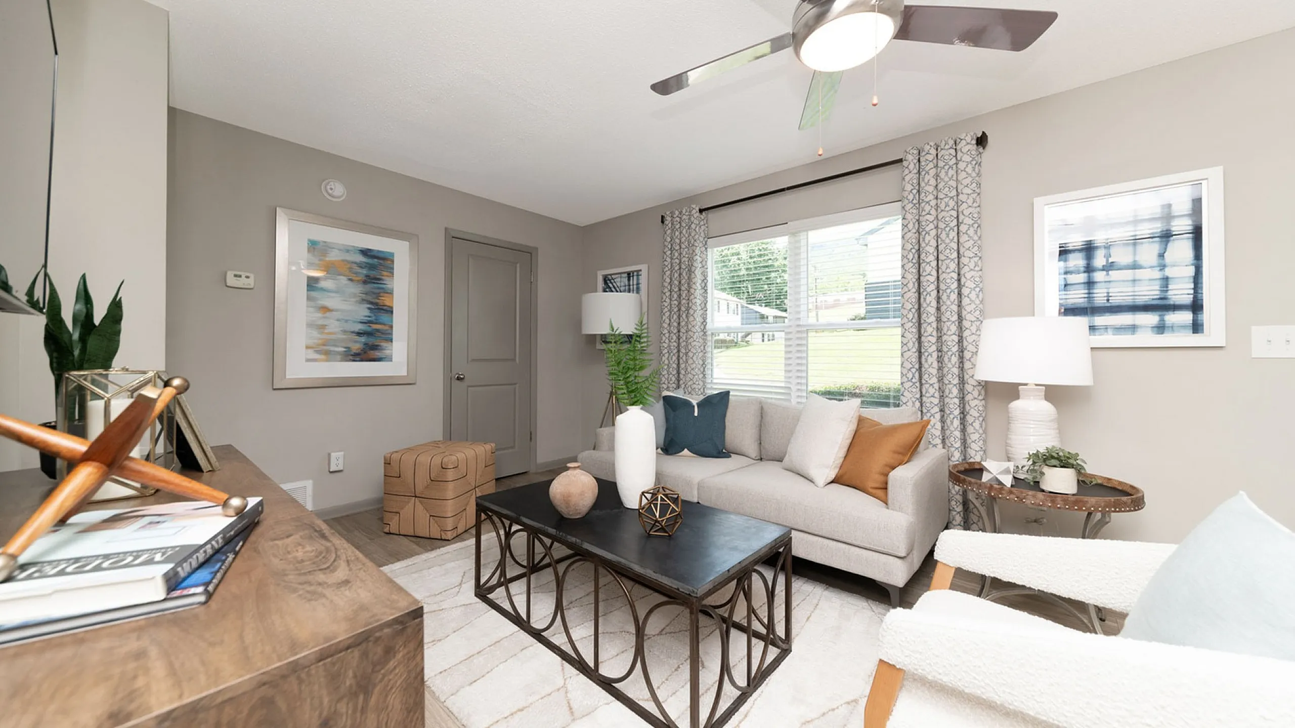 Bright and modern living room with stylish decor, featuring a comfortable sofa, chic coffee table, and large window for natural light.