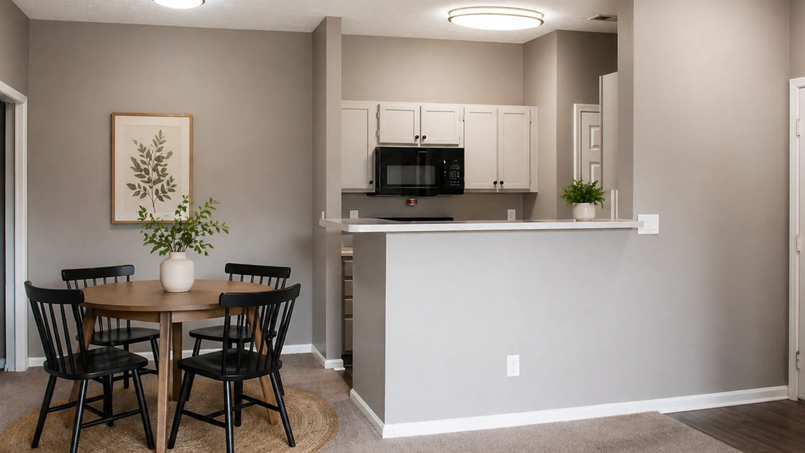 Elegant dining and kitchen area with modern lighting, classic wooden table set, and chic neutral decor.