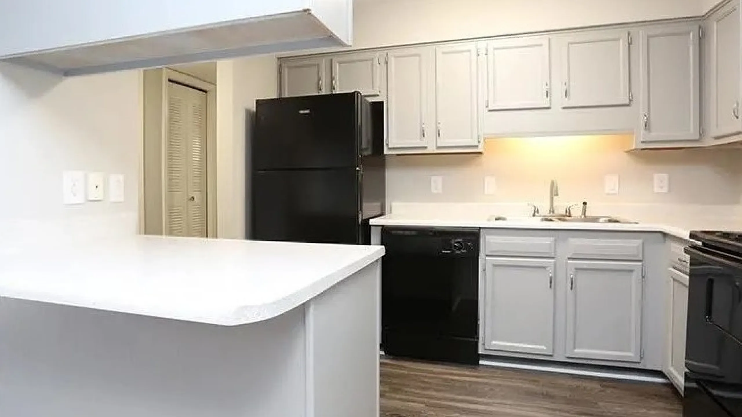 Bright and modern kitchen with sleek gray cabinetry, spacious countertops, and stylish lighting.