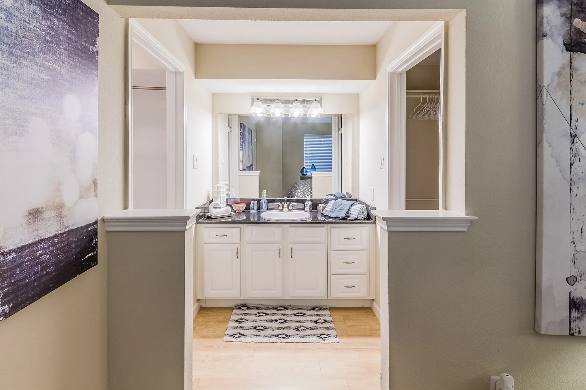 Elegant bathroom with sleek white cabinetry, modern lighting, and stylish decor, offering a serene and inviting atmosphere.