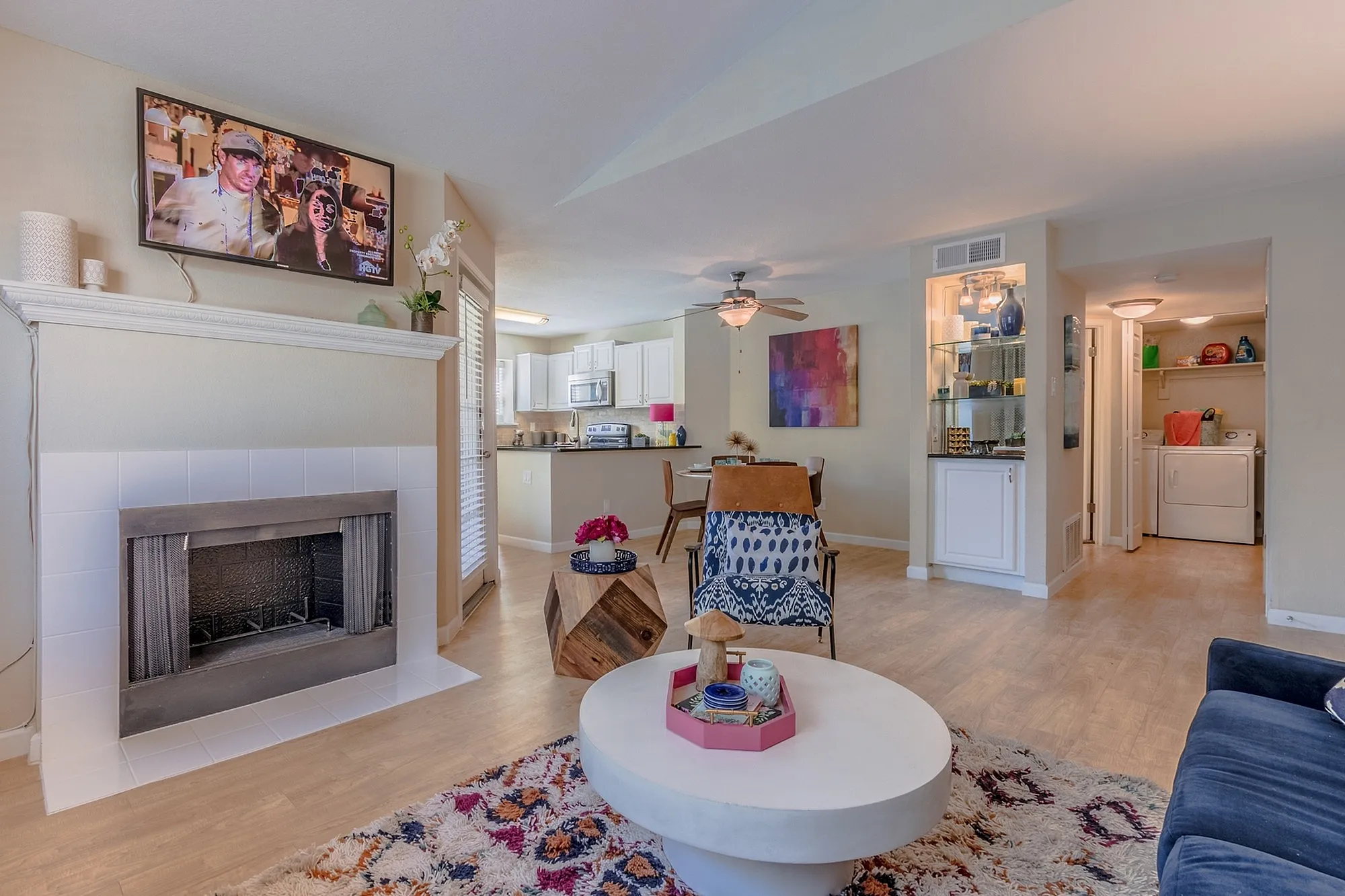 Inviting living room with cozy fireplace, modern open kitchen, and stylish decor in a bright, airy apartment.