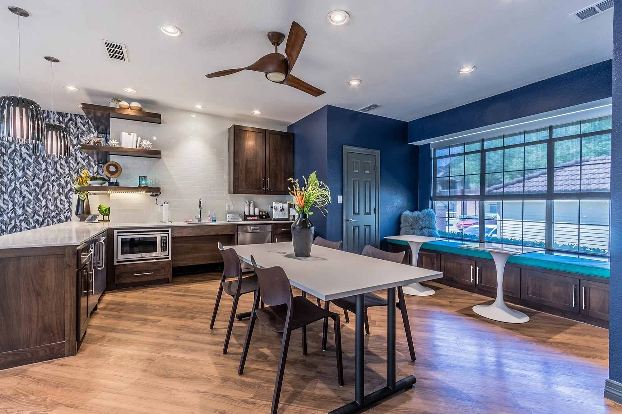 Contemporary kitchen and dining area featuring dark wood cabinetry, sleek countertops, and large windows offering natural light and scenic views.