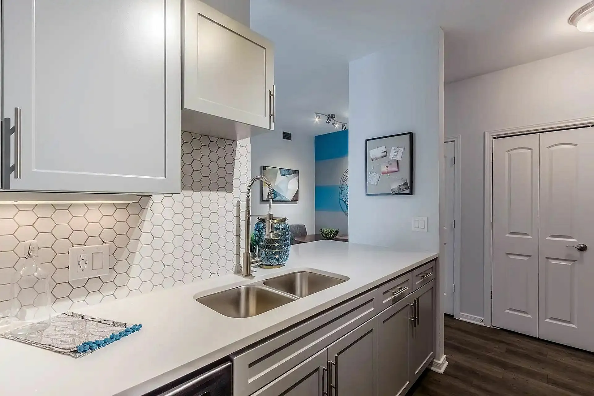 Sleek modern kitchen with elegant white cabinetry and stylish hexagonal backsplash tiles, offering a contemporary aesthetic.