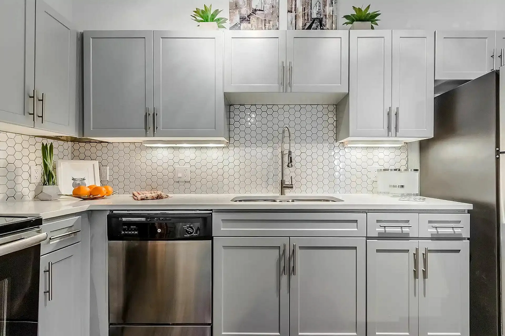 Modern kitchen with elegant cabinetry, sleek stainless steel appliances, and a stylish hexagonal tile backsplash.