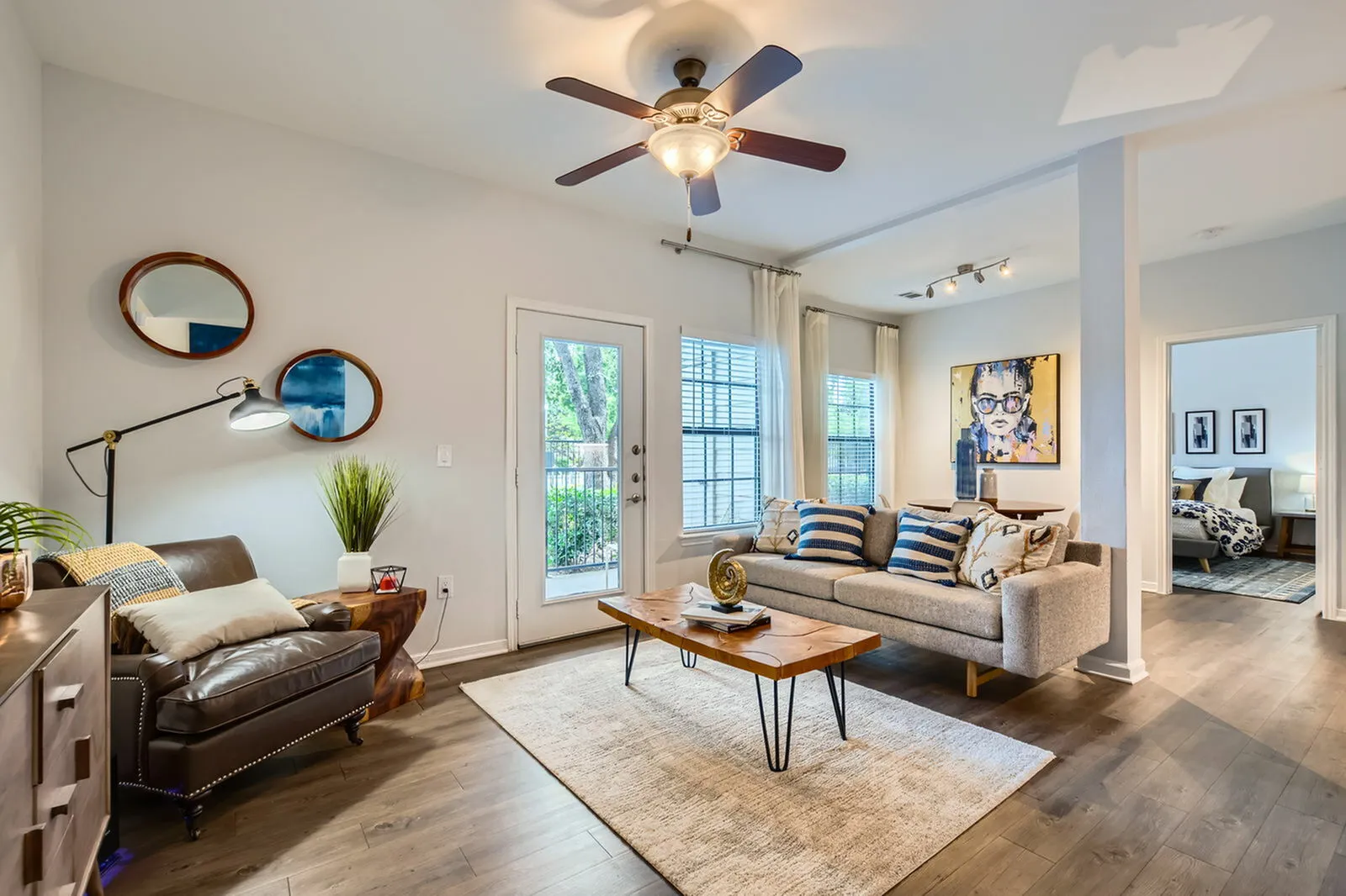 Bright and stylish living room with modern décor, featuring a cozy sofa, elegant wall art, and large windows offering natural light.