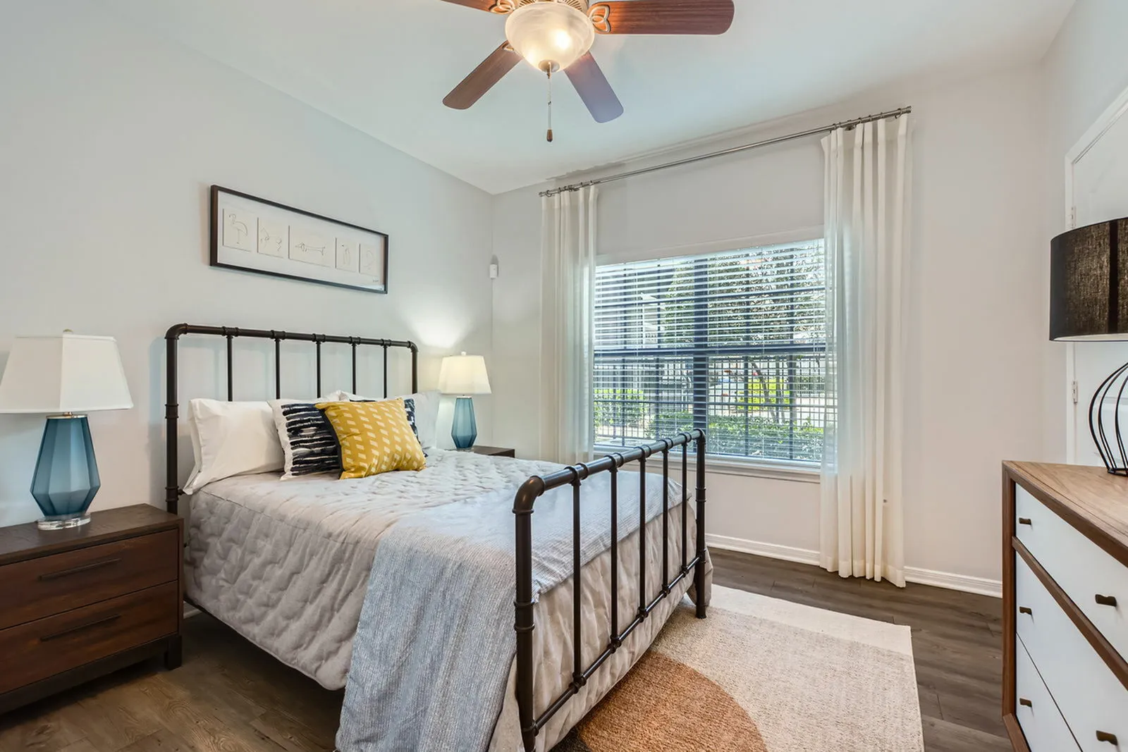 Inviting bedroom with stylish decor, featuring a cozy bed, elegant nightstands, and large window letting in natural light.