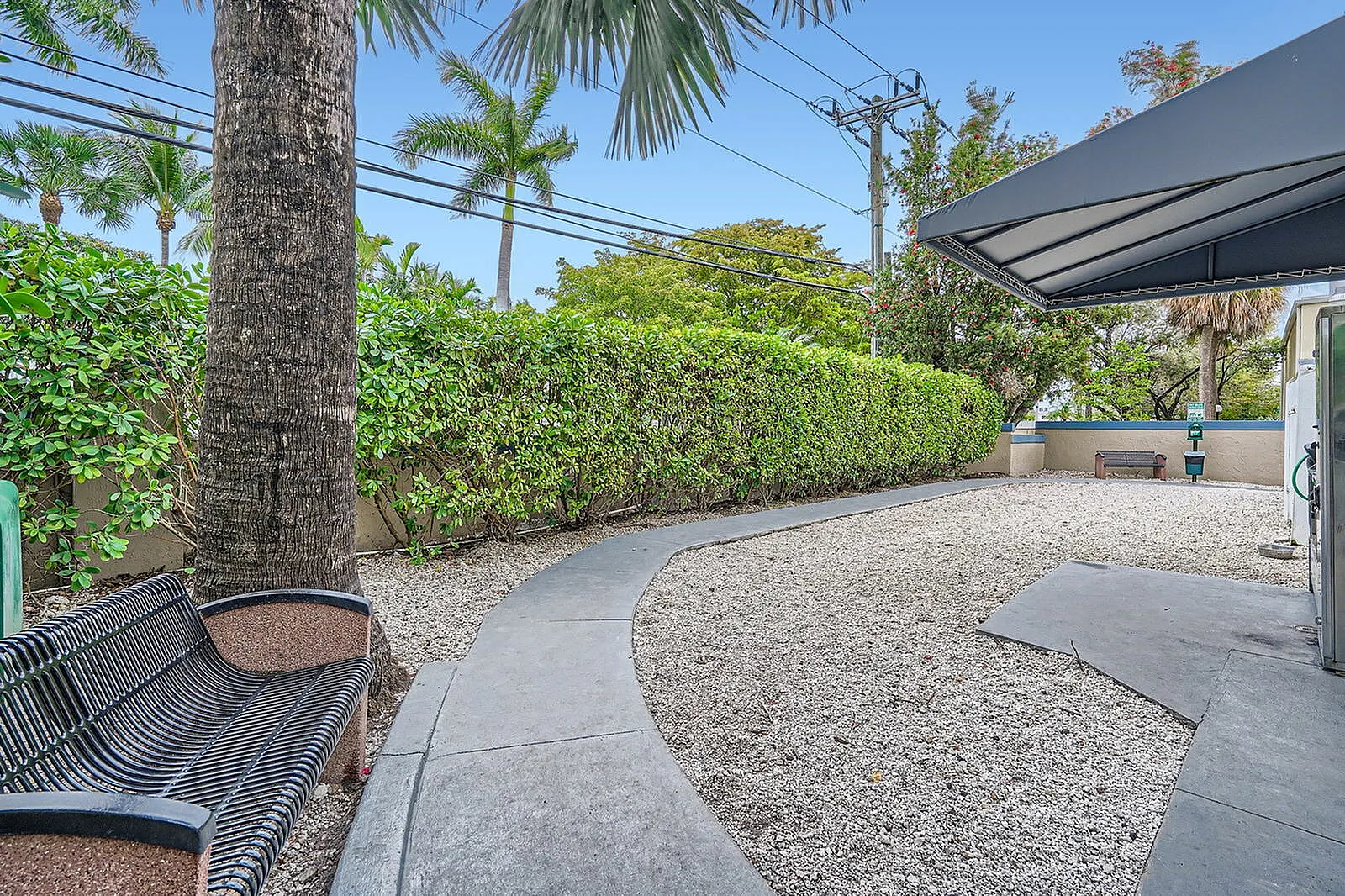 Inviting outdoor space with lush greenery, palm trees, and comfortable seating, perfect for relaxation and enjoying the fresh air.