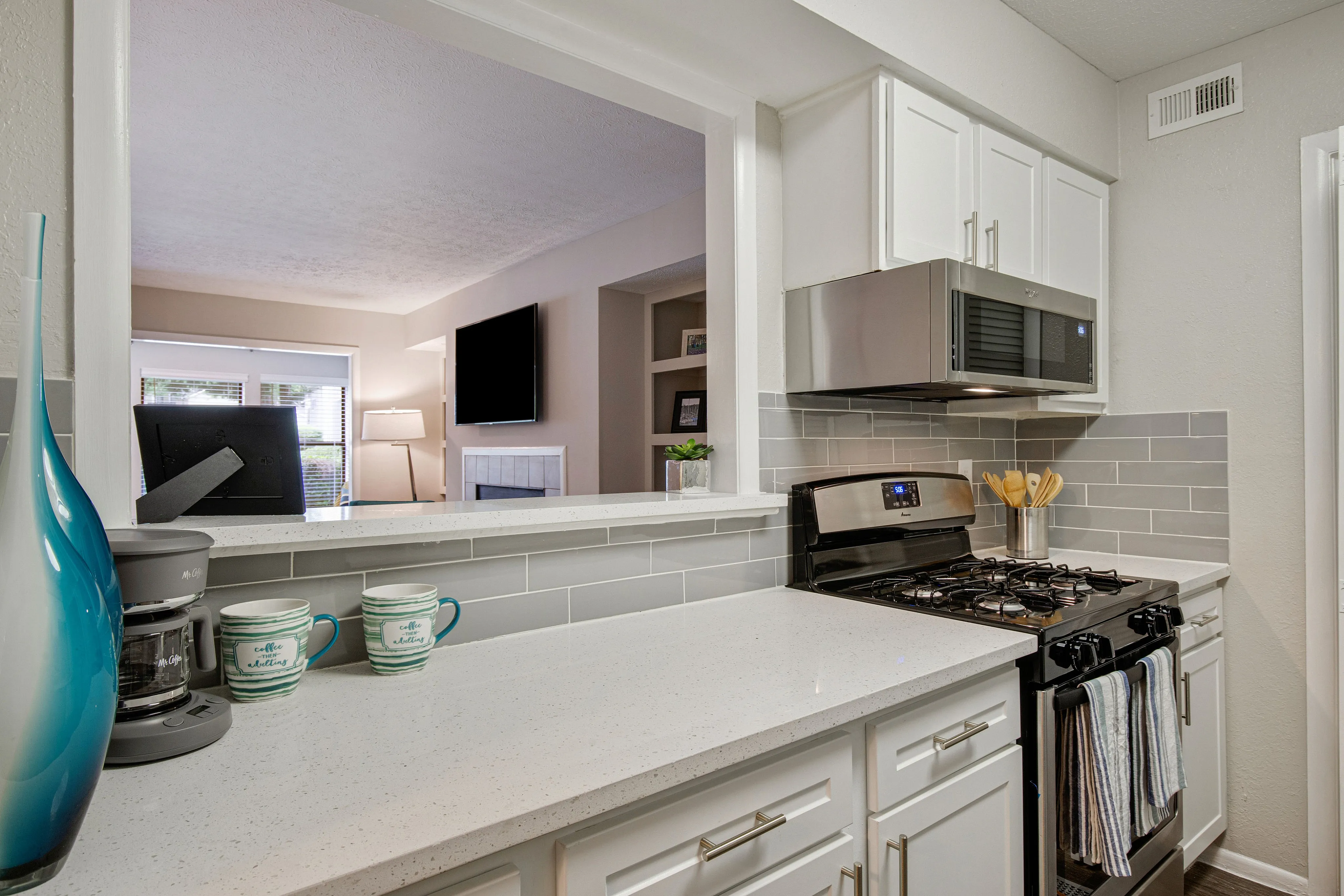 Modern kitchen with sleek countertops, stainless steel appliances, and a cozy breakfast bar overlooking the living room.