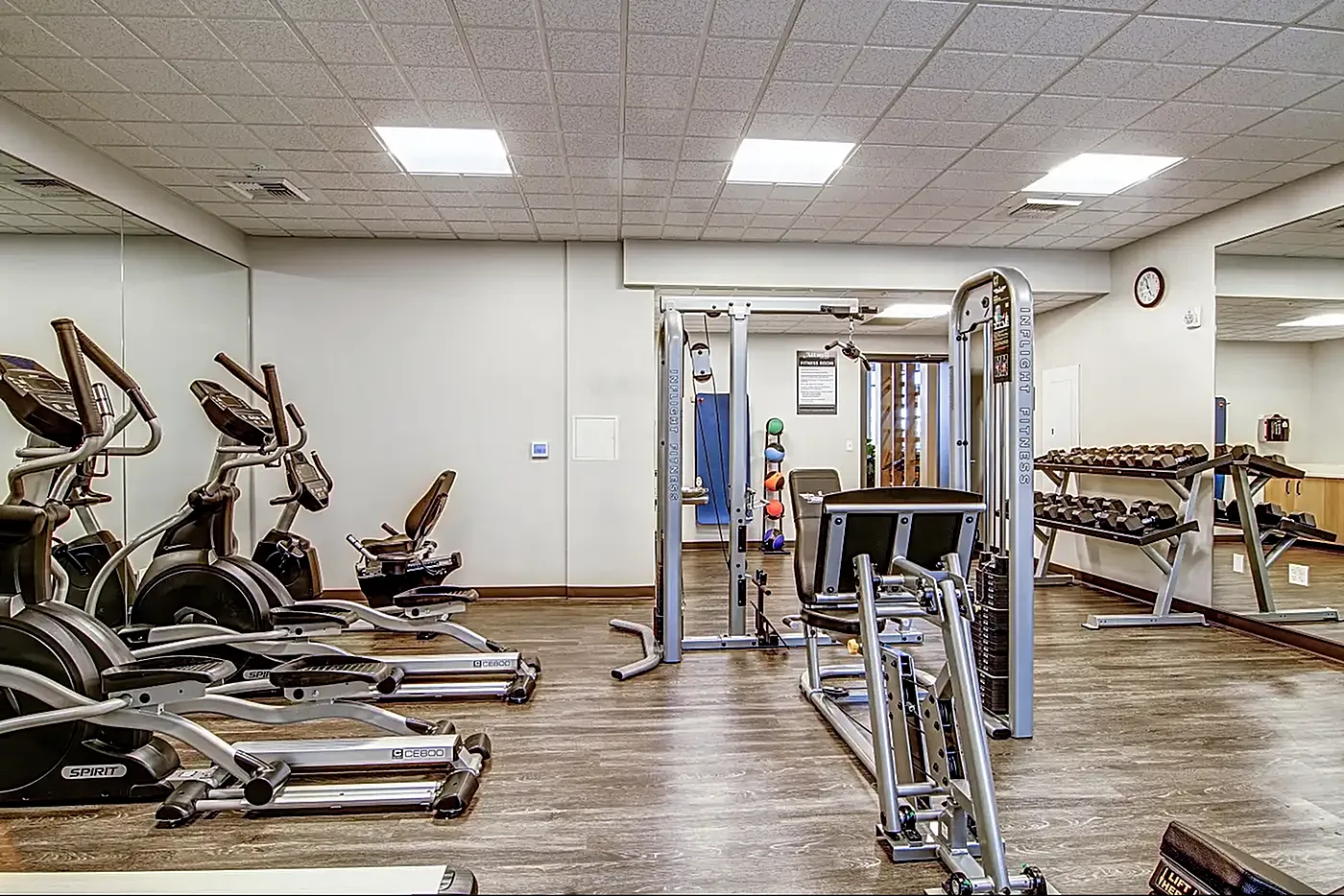 Modern fitness center featuring state-of-the-art exercise equipment and sleek wooden flooring, perfect for an energizing workout.