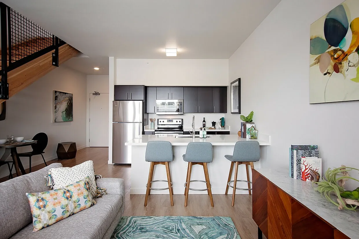 Modern open-plan living area with sleek kitchen, cozy seating, and stylish decor perfect for urban living.