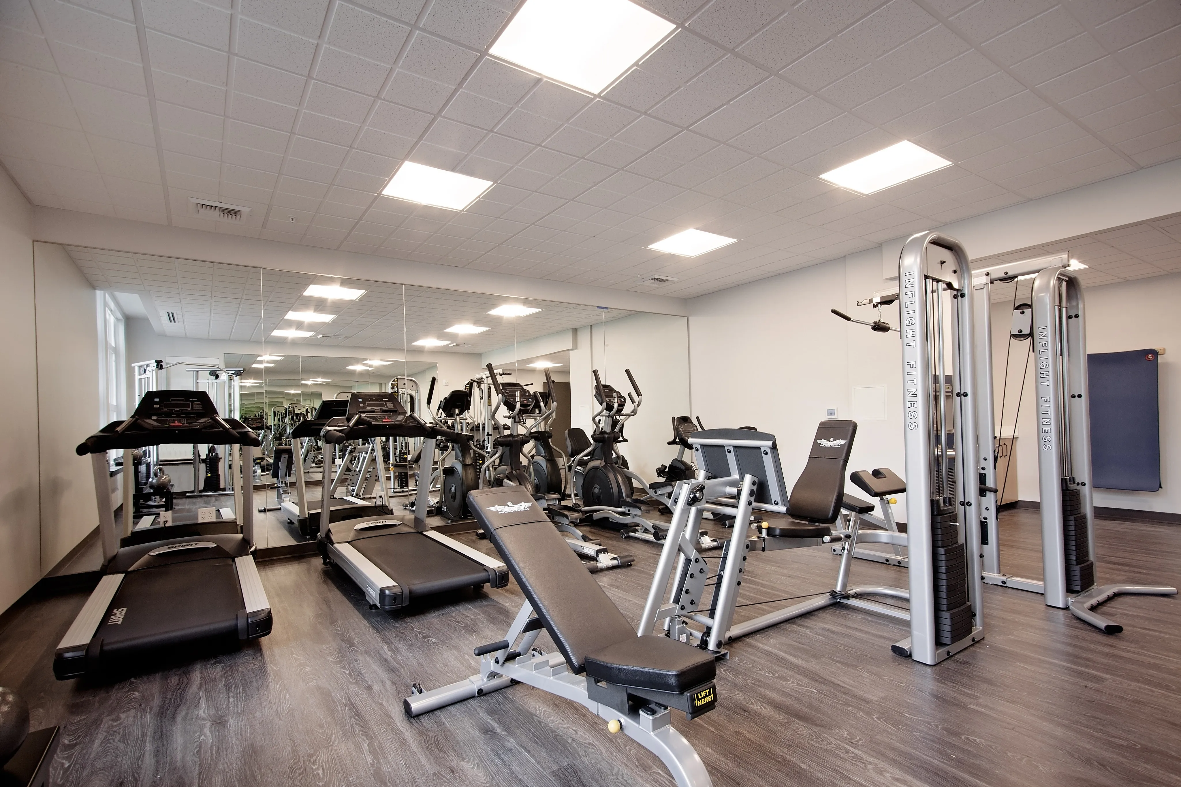 Modern fitness center with state-of-the-art equipment, featuring treadmills, weight machines, and a mirrored wall for optimal workout experience.