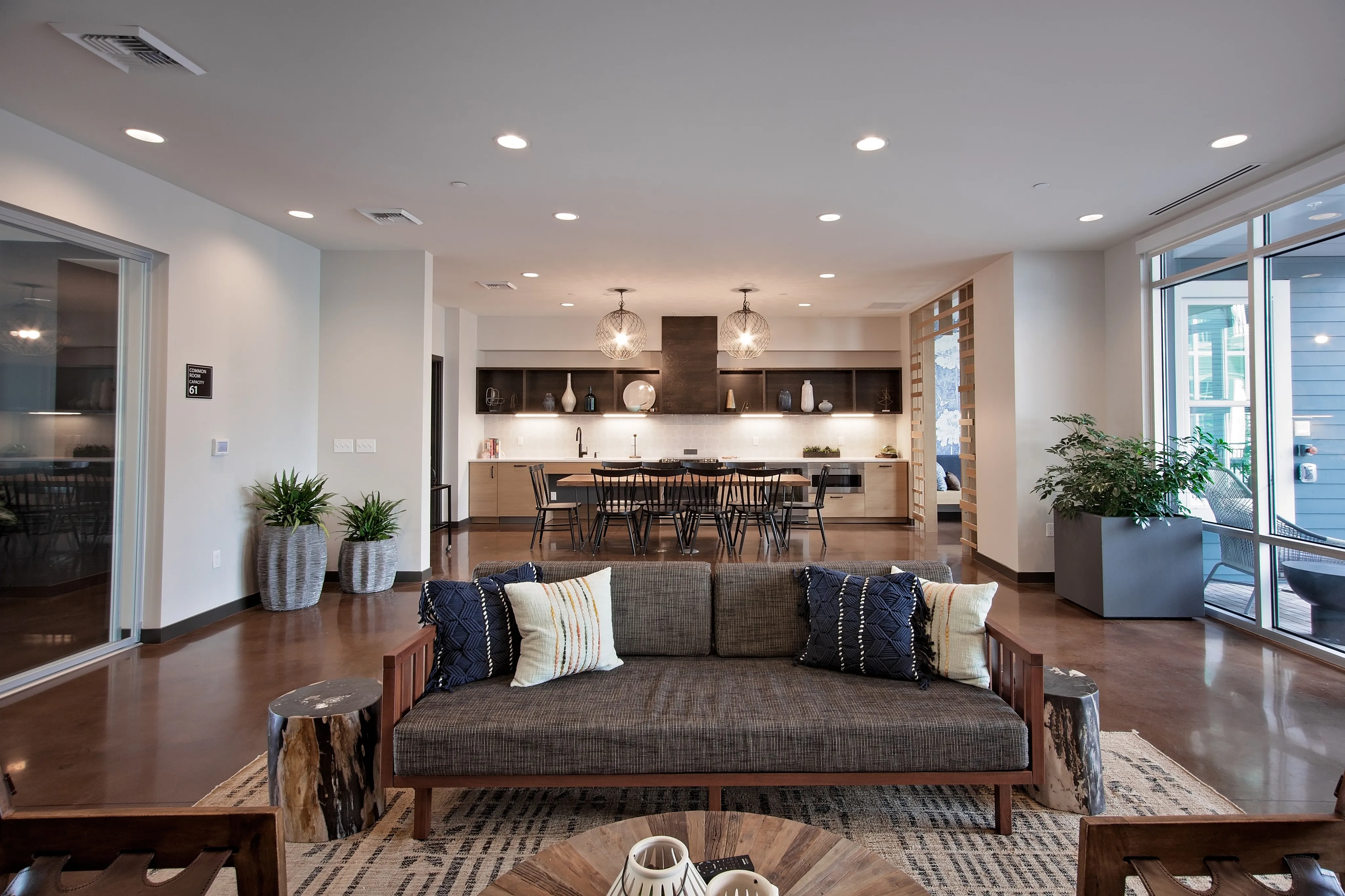 Chic open-concept living space featuring a modern kitchen, cozy seating area, and elegant decor with abundant natural light.