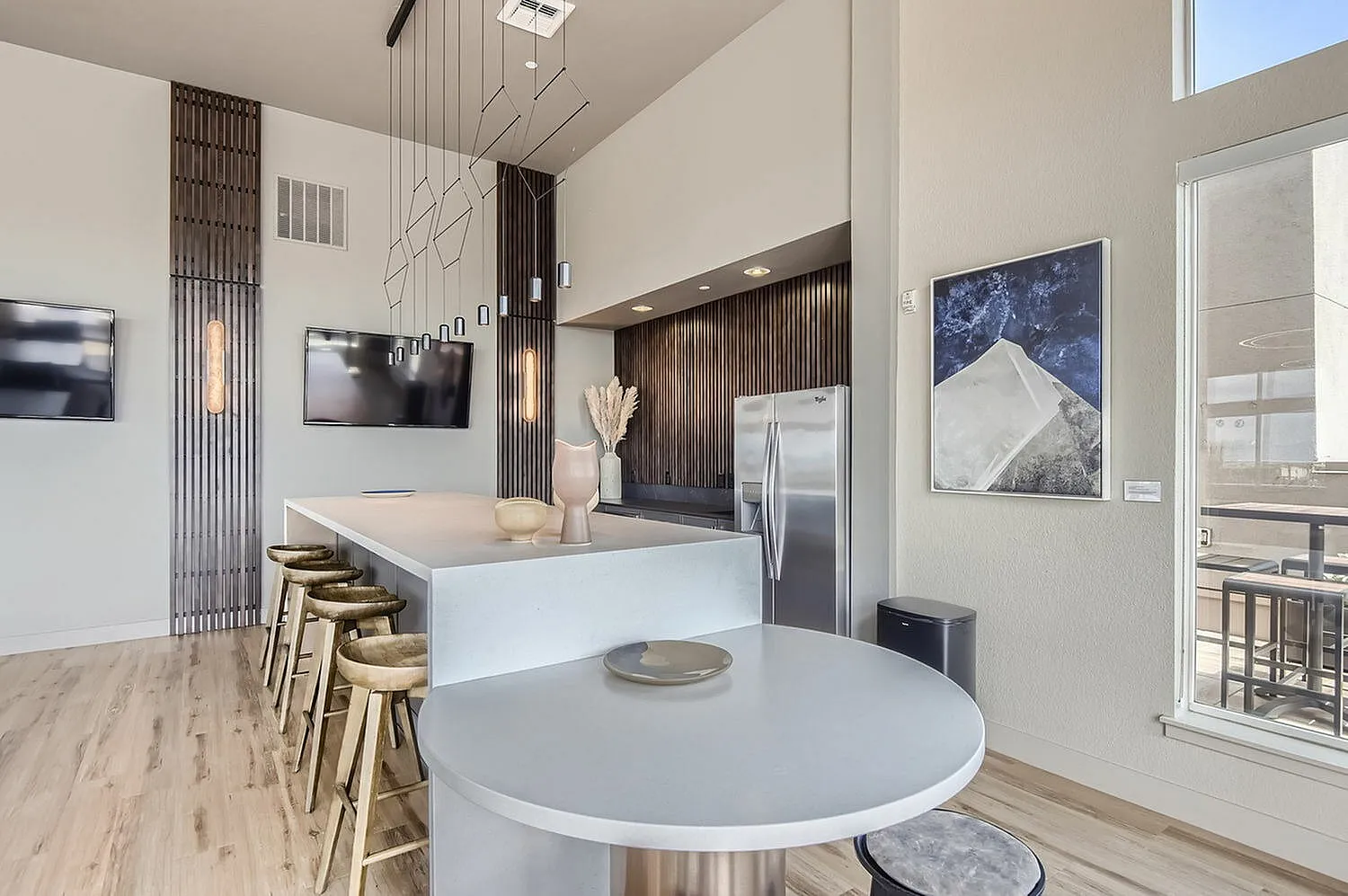 Sophisticated modern kitchen with sleek countertops, stylish pendant lighting, and chic bar stools, perfect for entertaining.
