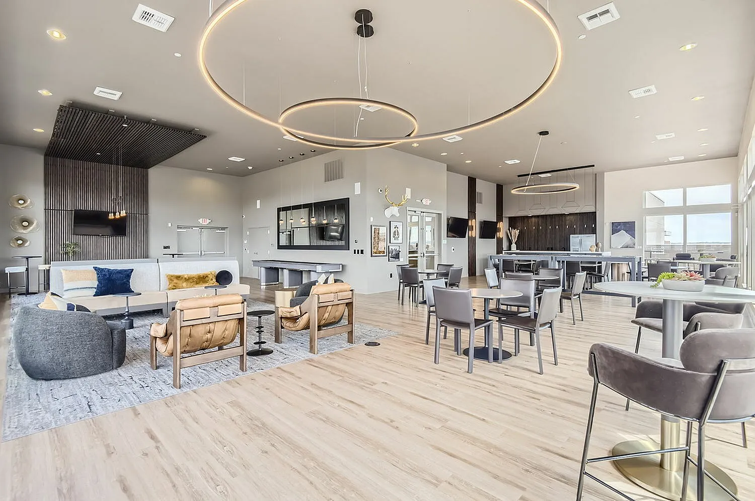 Luxurious and inviting open-concept lounge area featuring contemporary seating, elegant lighting fixtures, and a chic bar setup, perfect for social gatherings and relaxation.