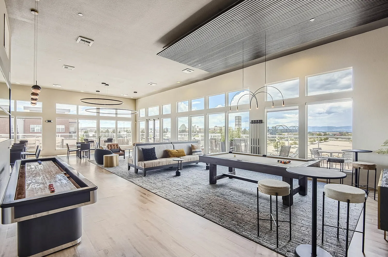 Luxurious community lounge with elegant game tables, stylish seating, and expansive windows offering stunning views.