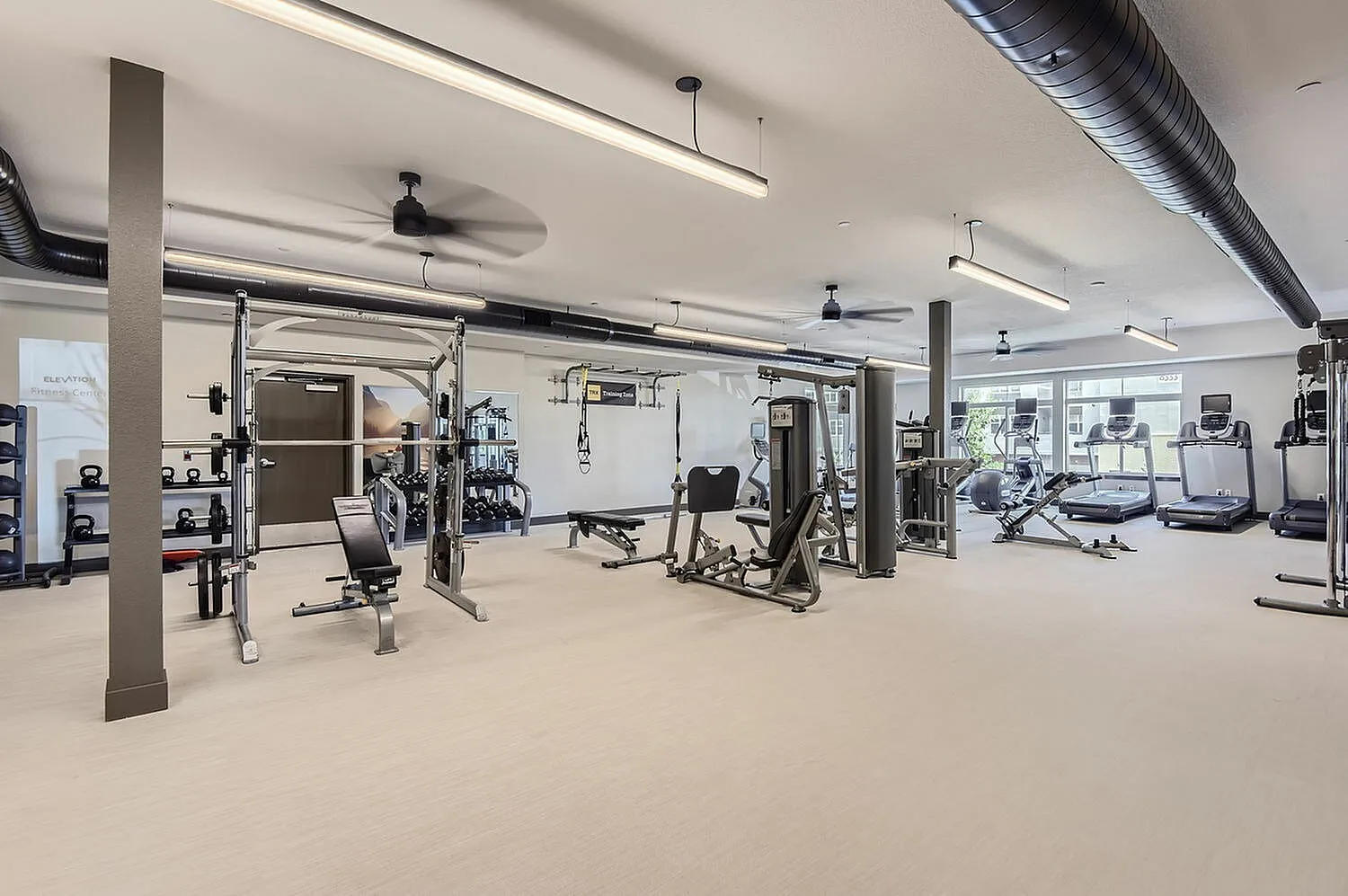 State-of-the-art fitness center with modern gym equipment, featuring a variety of cardio machines and weight stations.