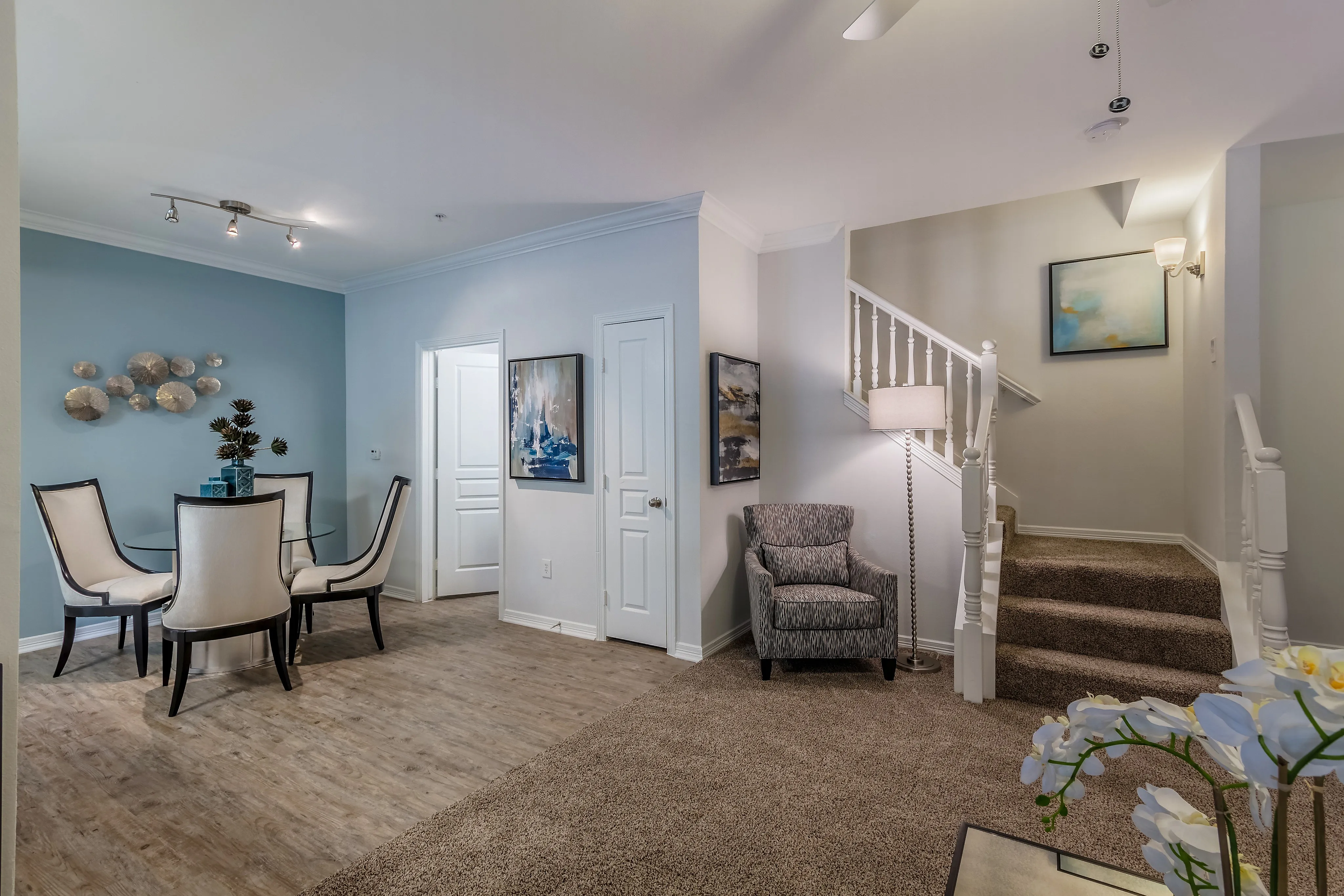 Elegant and inviting living space featuring modern decor, stylish dining area, and a cozy staircase.
