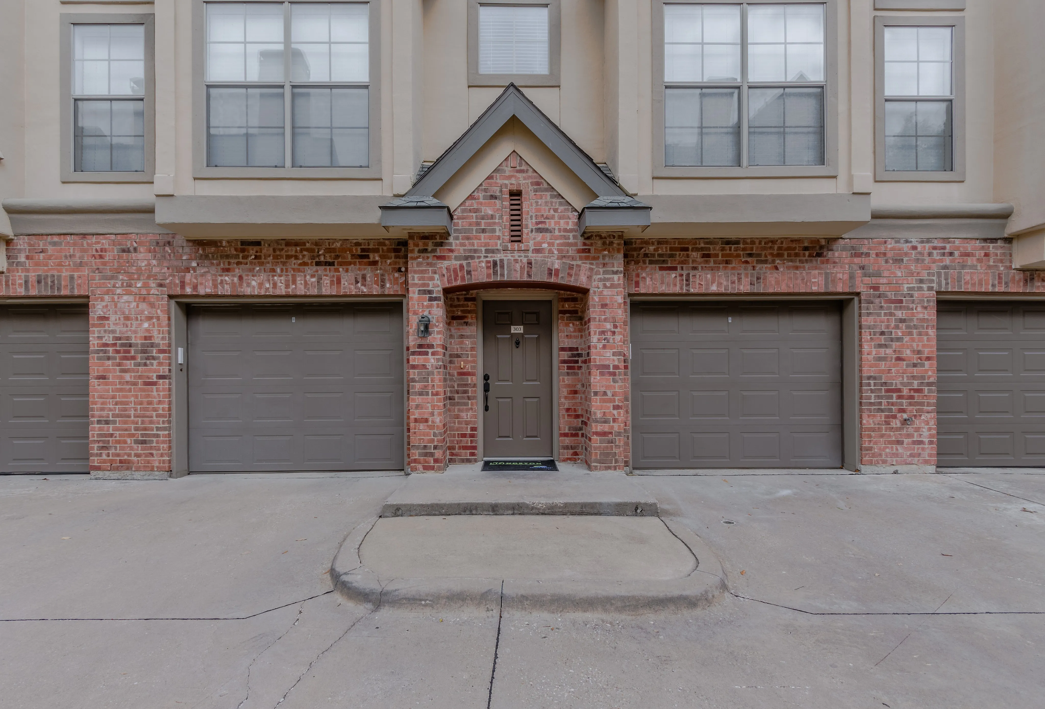 Stunning townhouse entrance with elegant brick facade and dual garages.