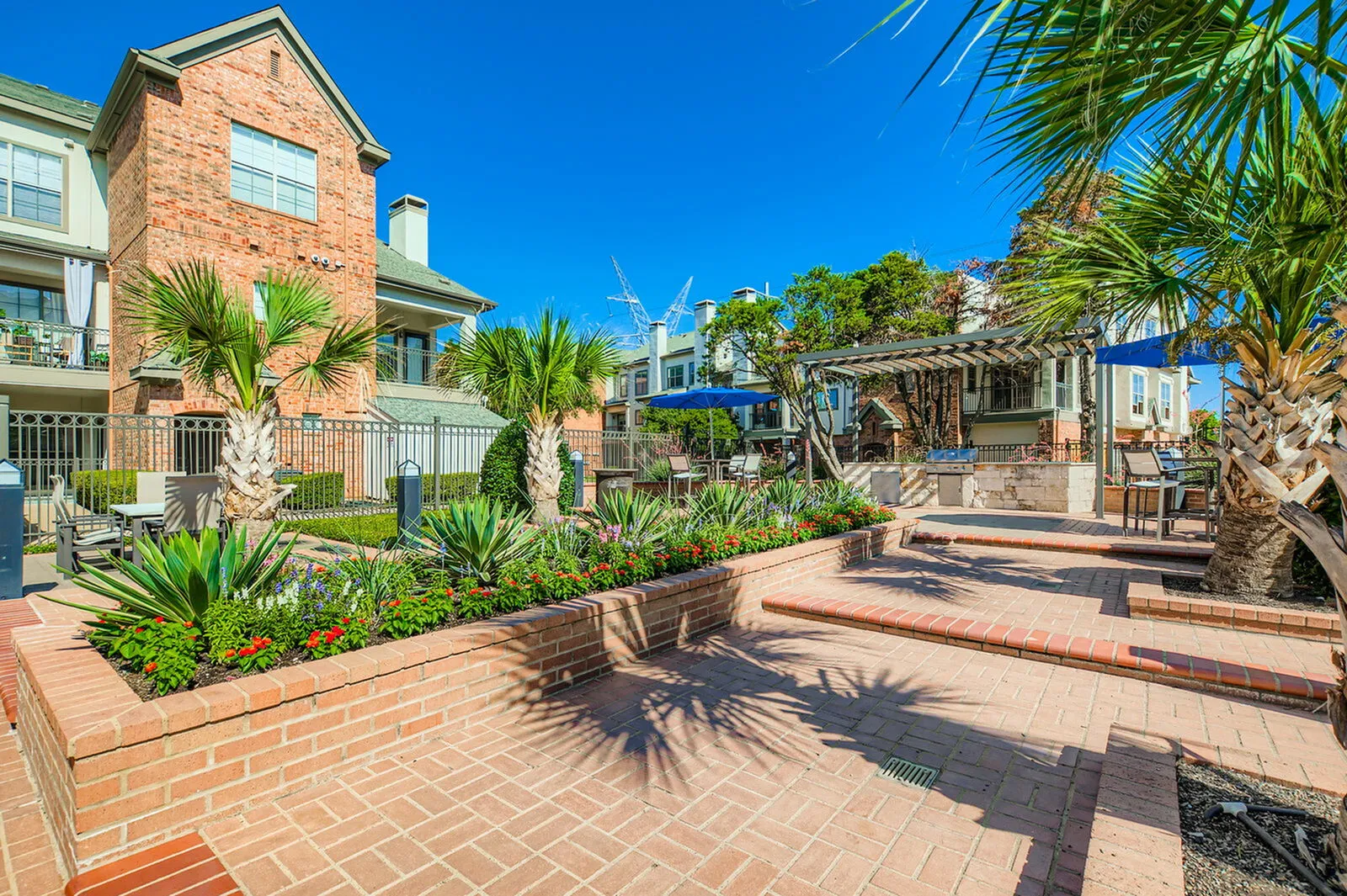 Charming outdoor patio area with vibrant landscaping, stylish brickwork, and a serene seating space for relaxation.