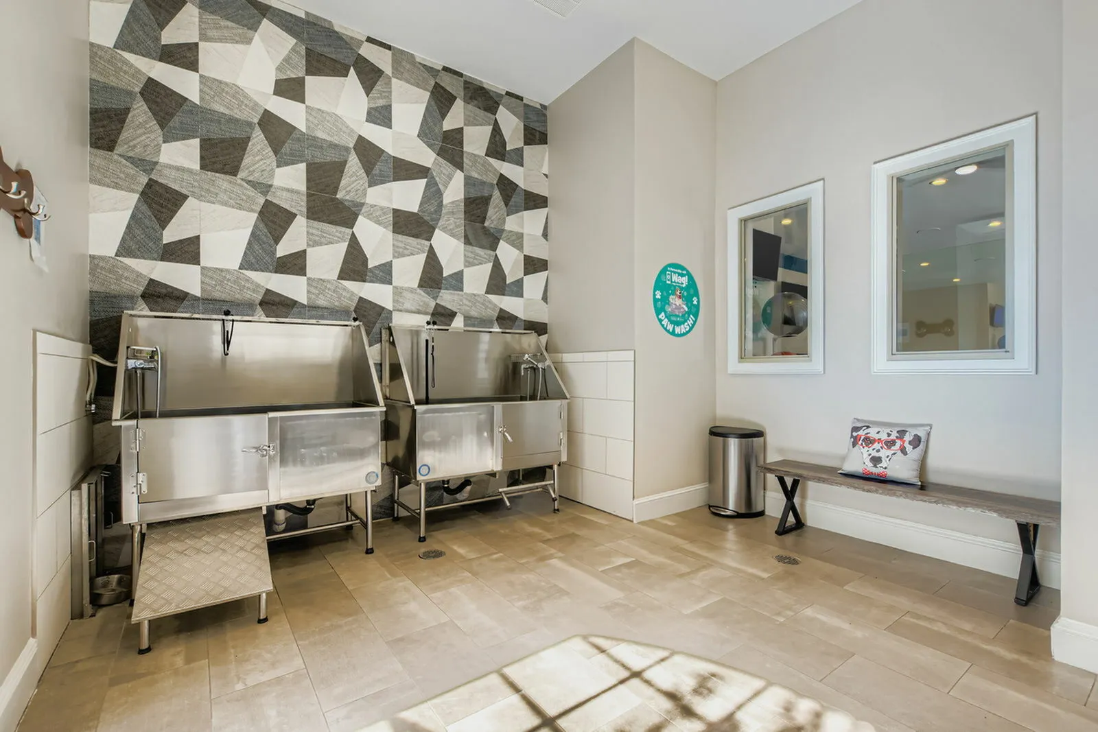 Modern pet wash station with sleek stainless steel tubs and stylish geometric wall tiles, perfect for a convenient grooming experience.
