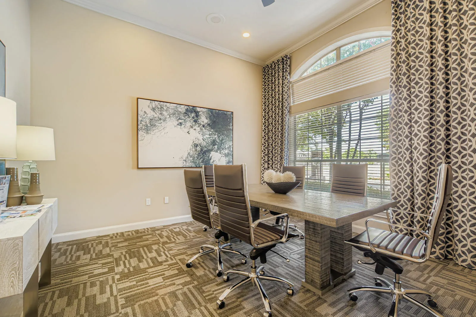Elegant conference room with modern design, featuring a stylish wooden table, comfortable swivel chairs, and large windows providing ample natural light.
