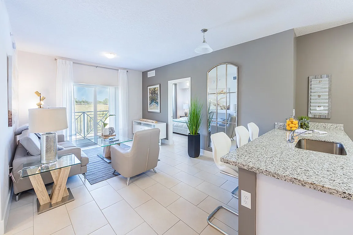 Bright and modern open-plan living space with a stylish kitchen, cozy seating area, and large windows overlooking a scenic view.