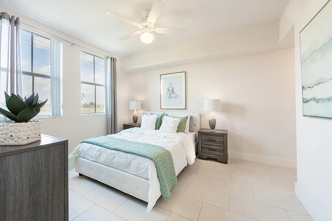 Bright and inviting bedroom with large windows, modern decor, and a plush bed, perfect for relaxation and comfort.